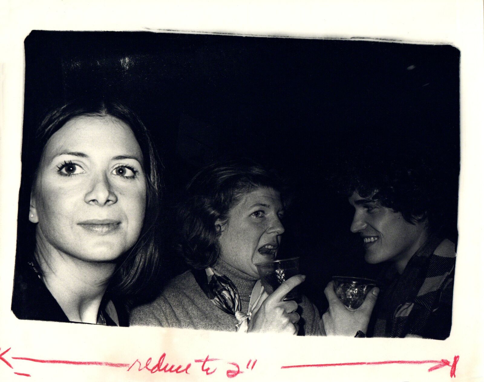 A black and white photo of a group of people at a party.