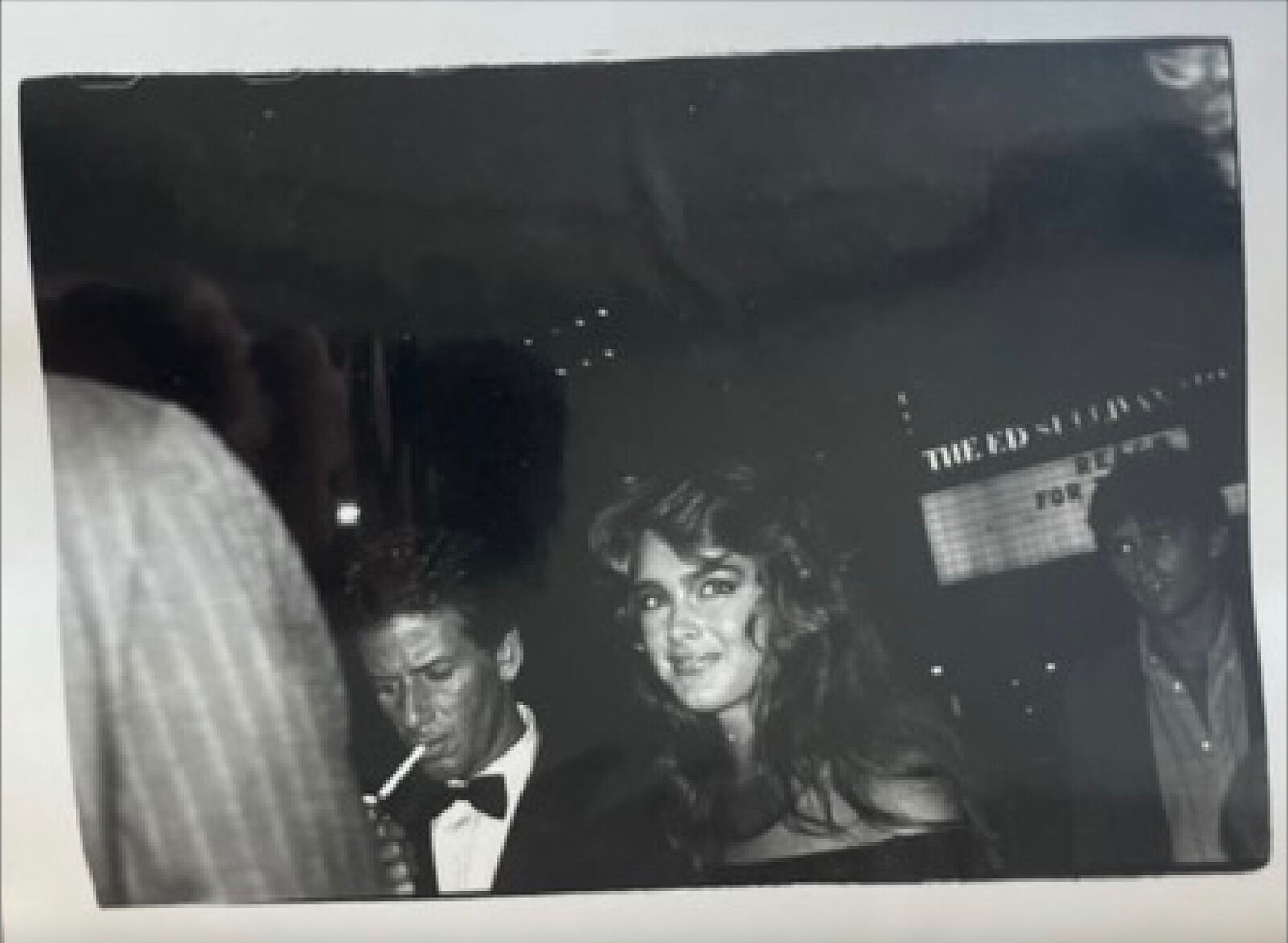 A black and white photo of a man and a woman at a party.