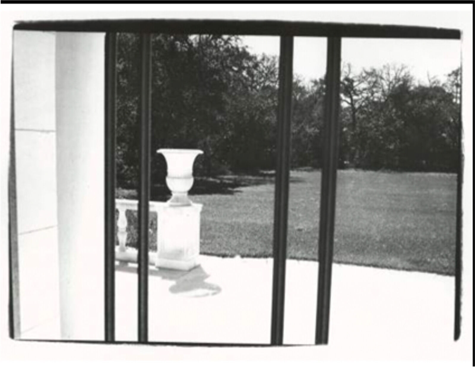 A black and white photo of a vase sitting on top of a table.