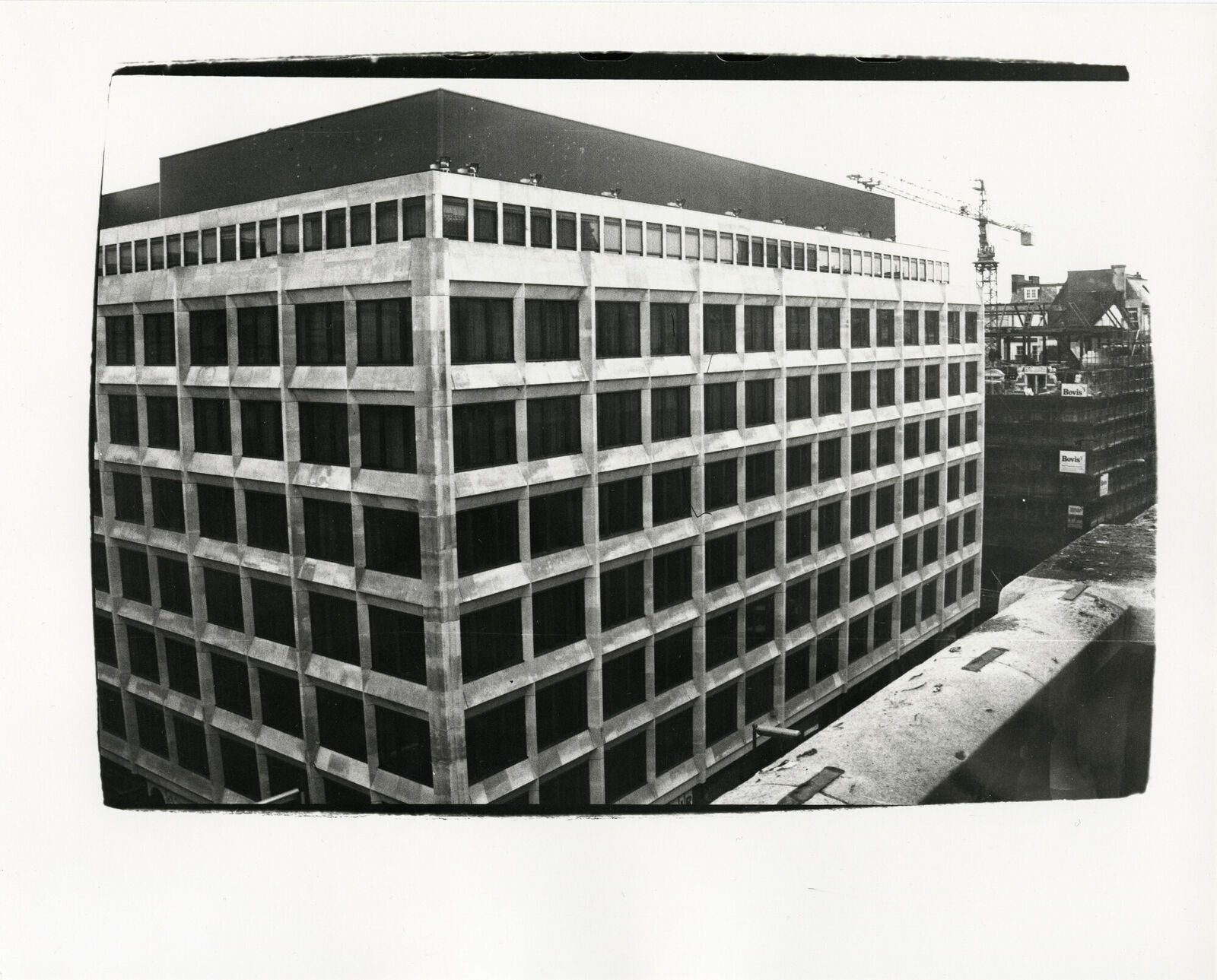 A black and white photo of a tall building under construction.