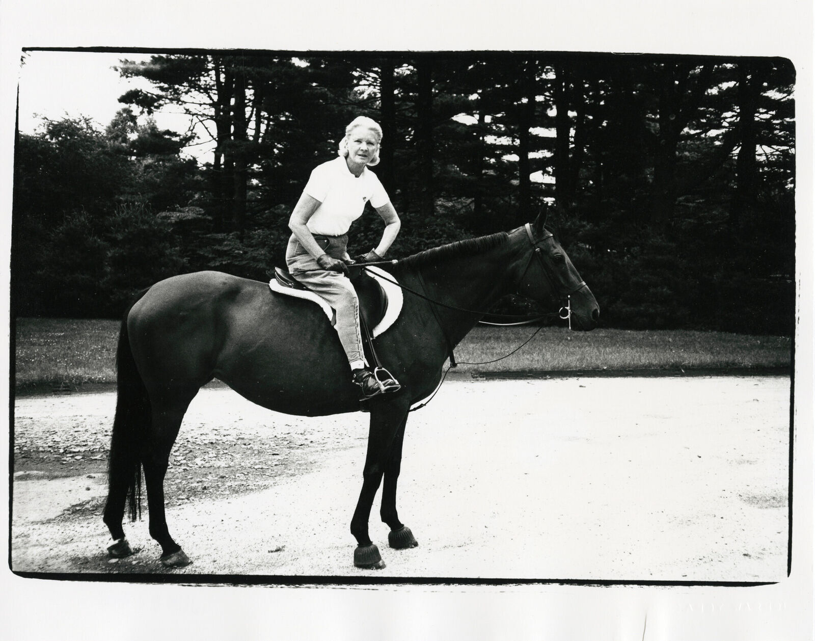 A woman riding on the back of a black horse.