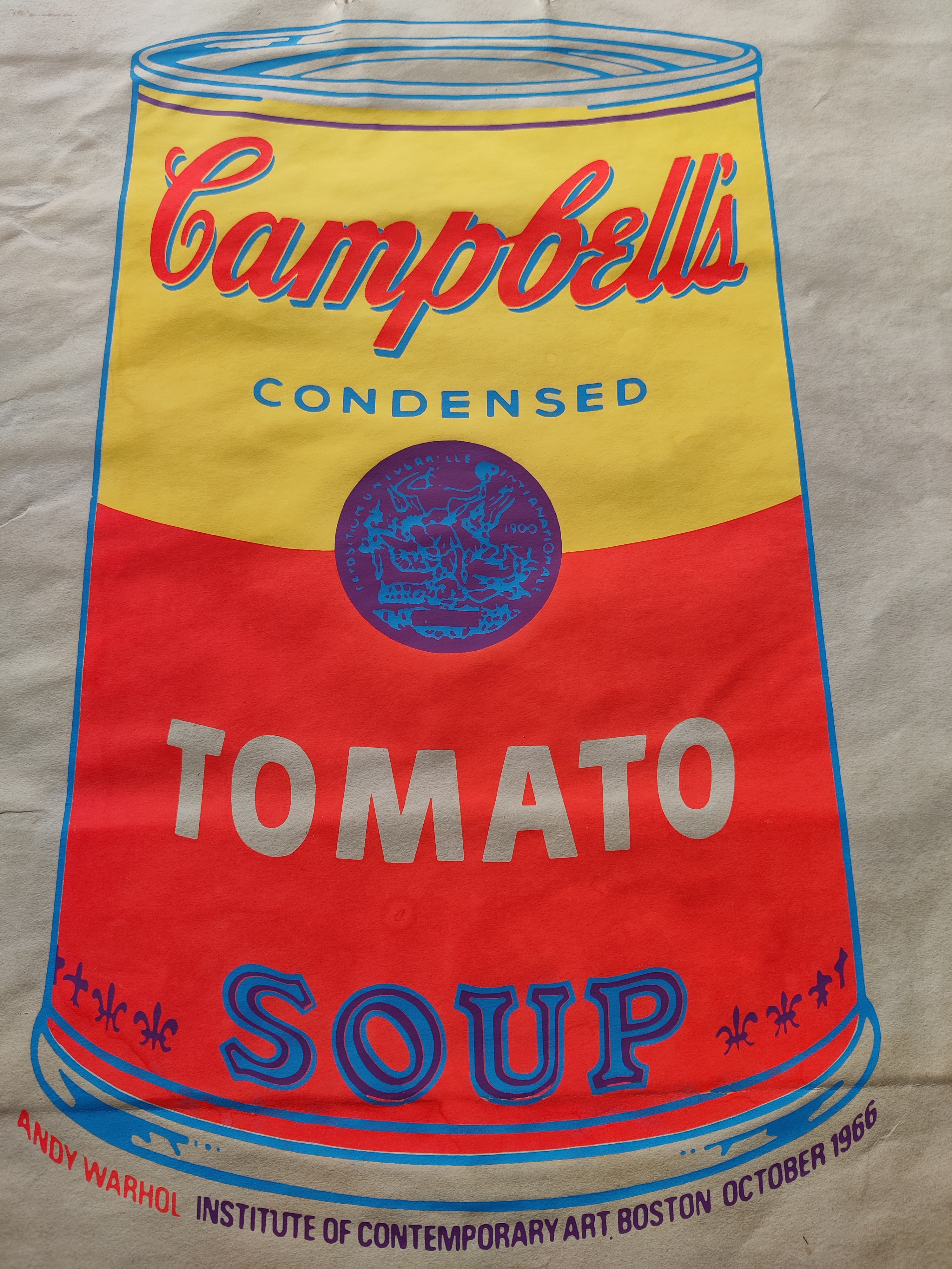 A paper bag printed with a stylized soup can design featuring bold colors and retro typography.