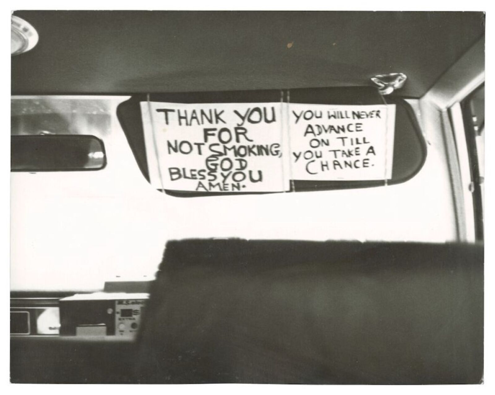 A sign on the back seat of a car that says thank you for not smoking.