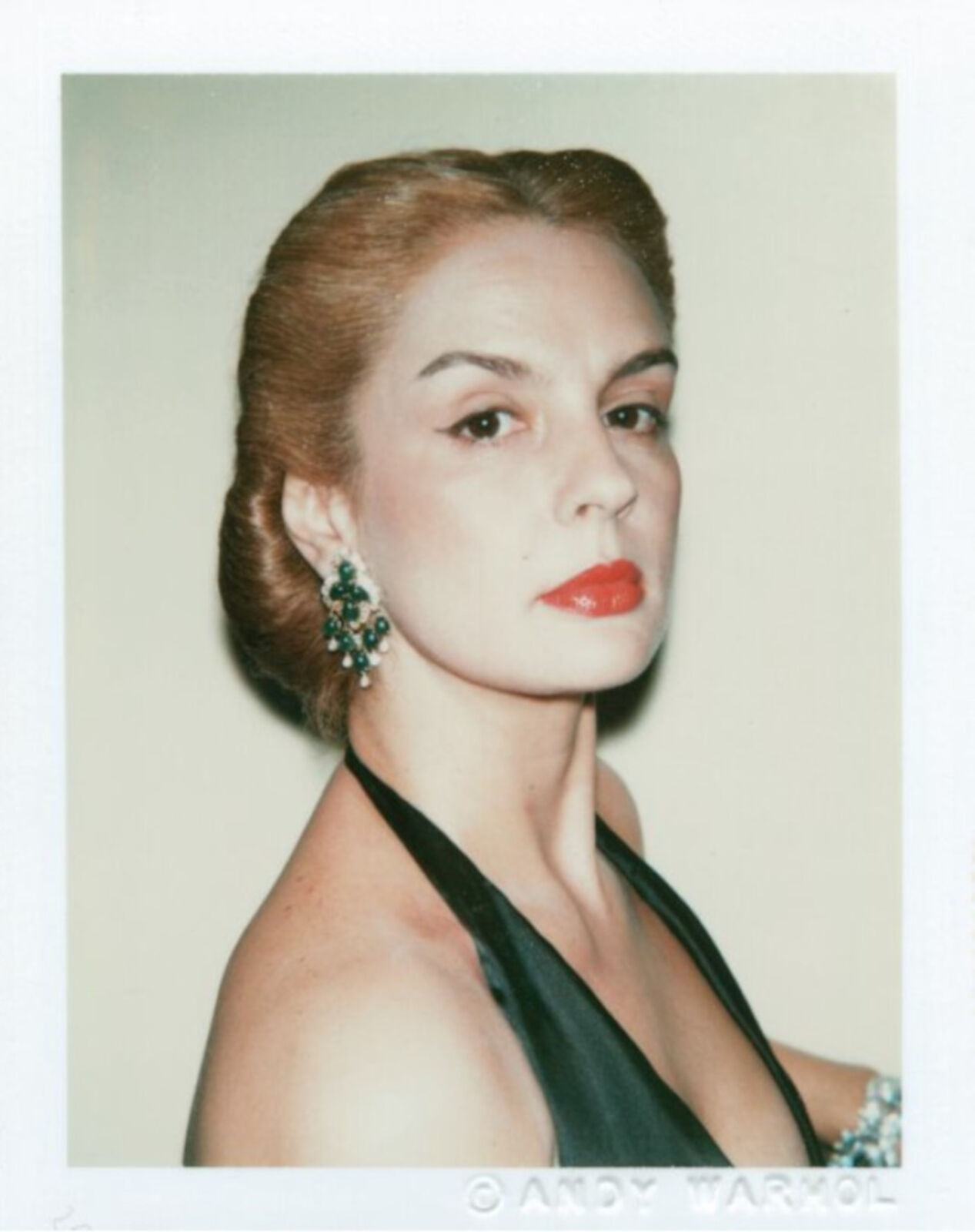 A woman in a black dress with red lipstick.