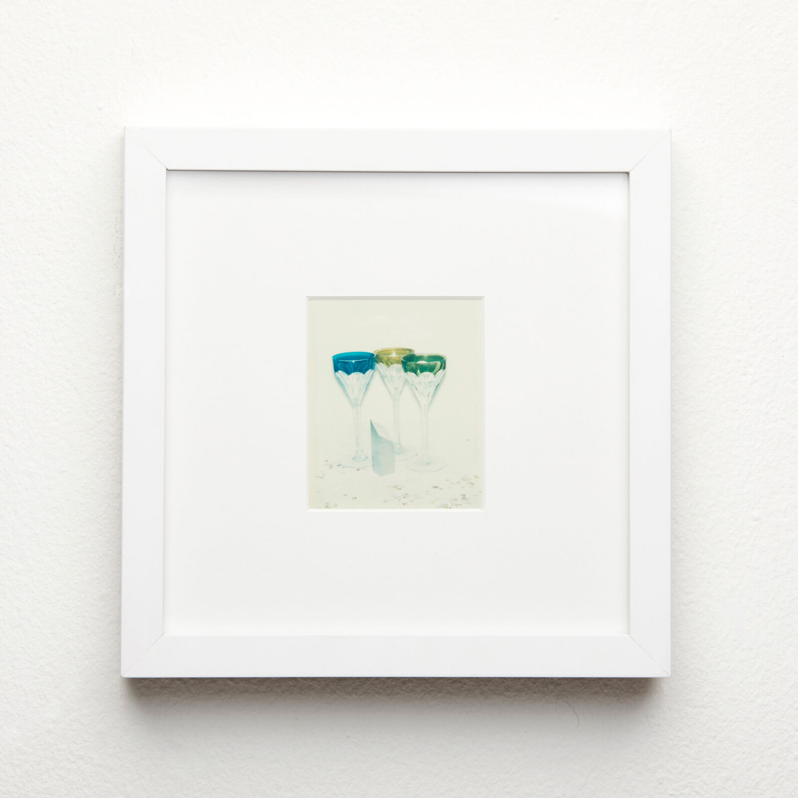 A picture of three glasses of wine on a white wall.