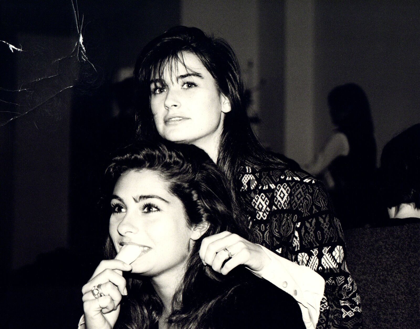 A black and white photo of two women eating ice cream.