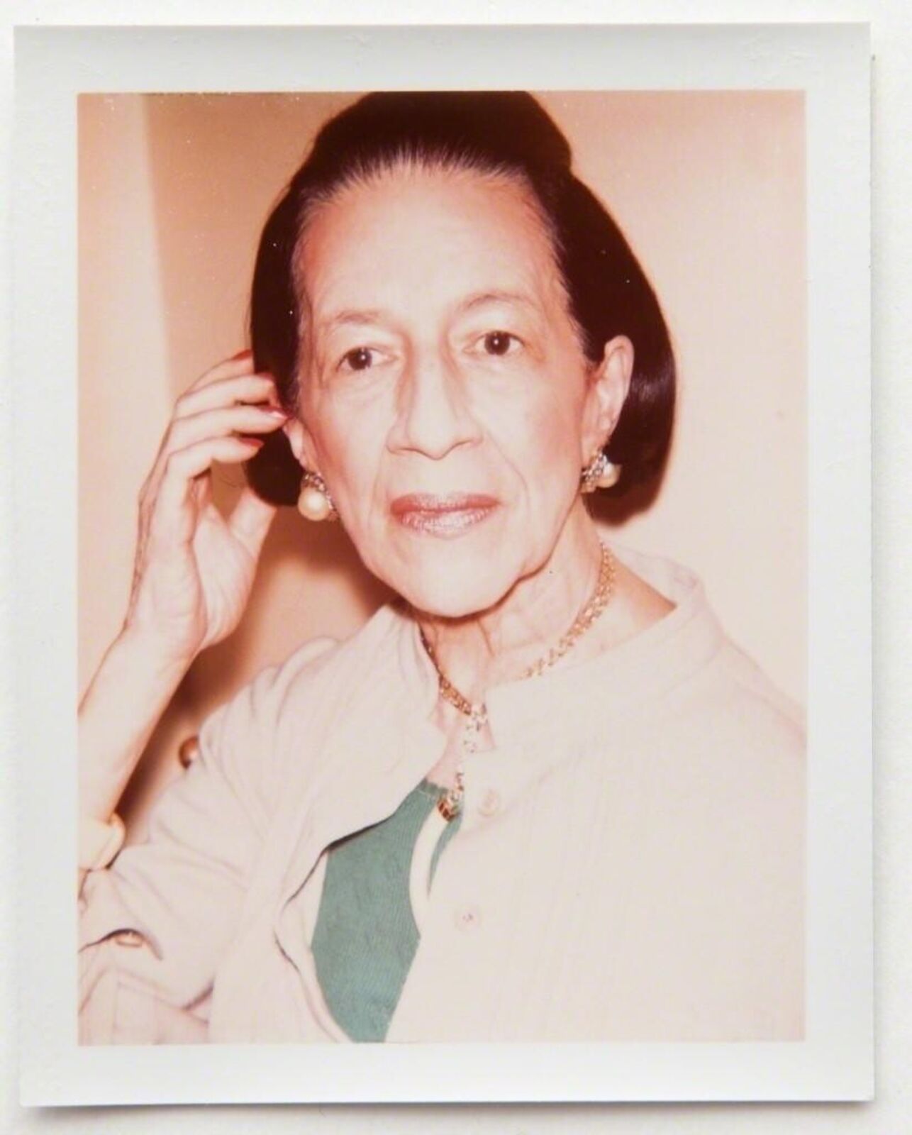 A polaroid photo of a woman talking on a cell phone.