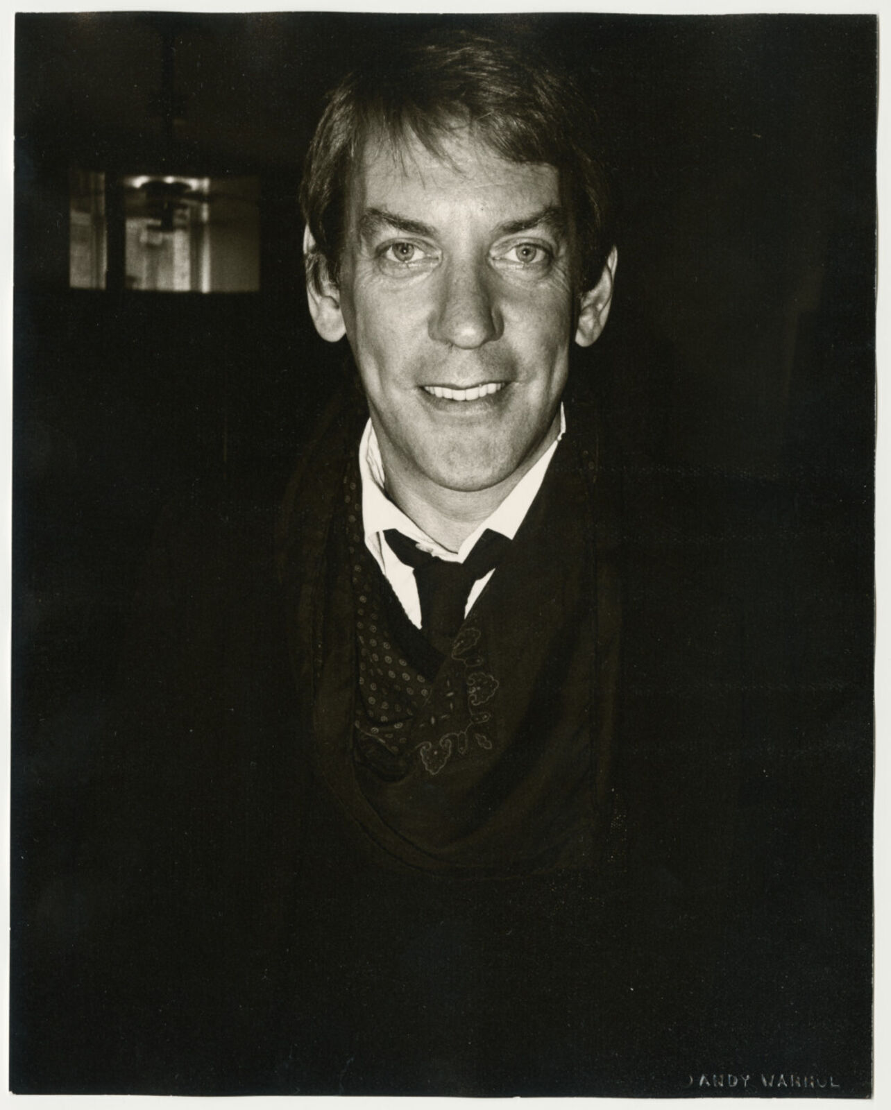 A black and white photo of a man in a suit and tie.