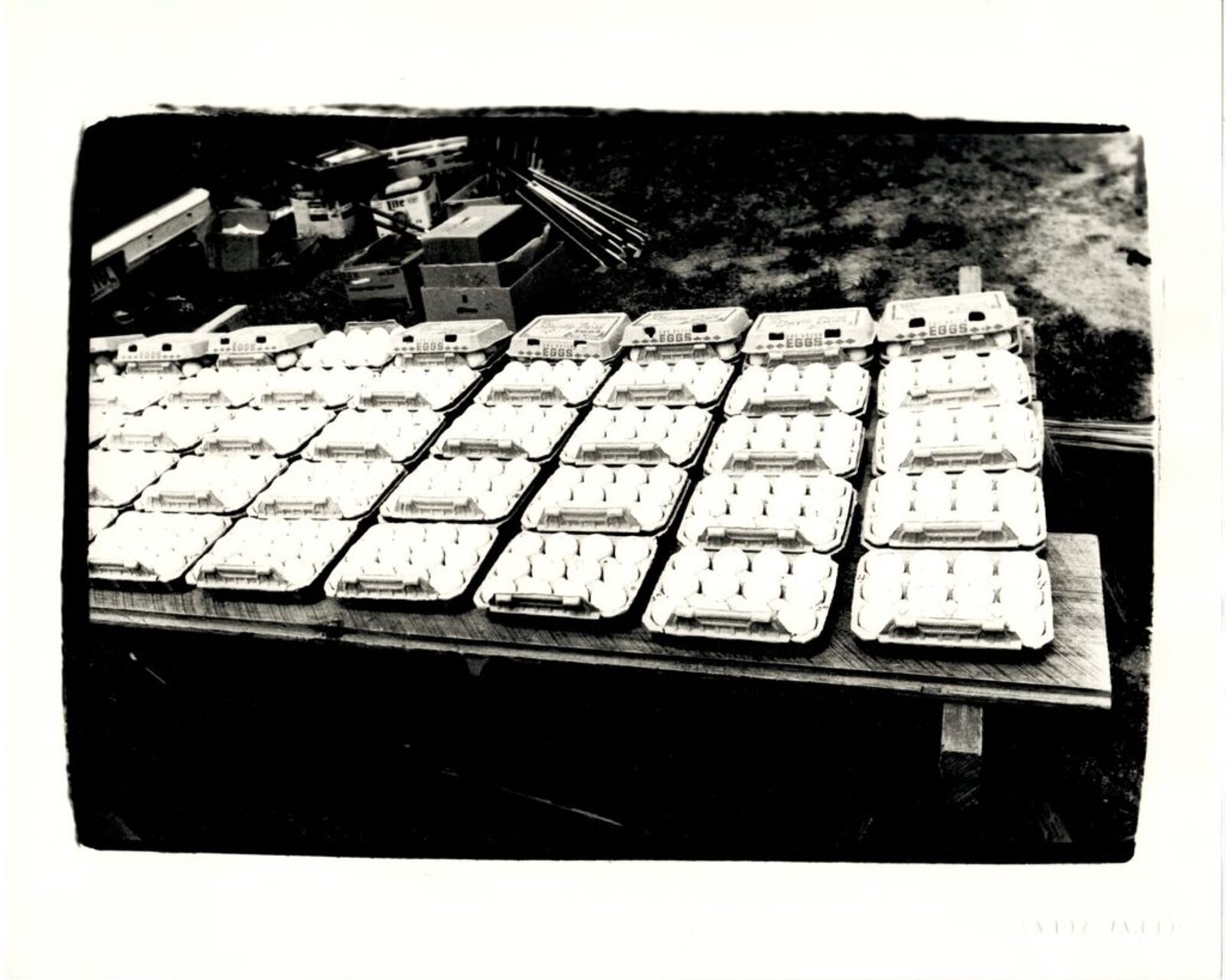 A black and white photo of a table full of eggs.