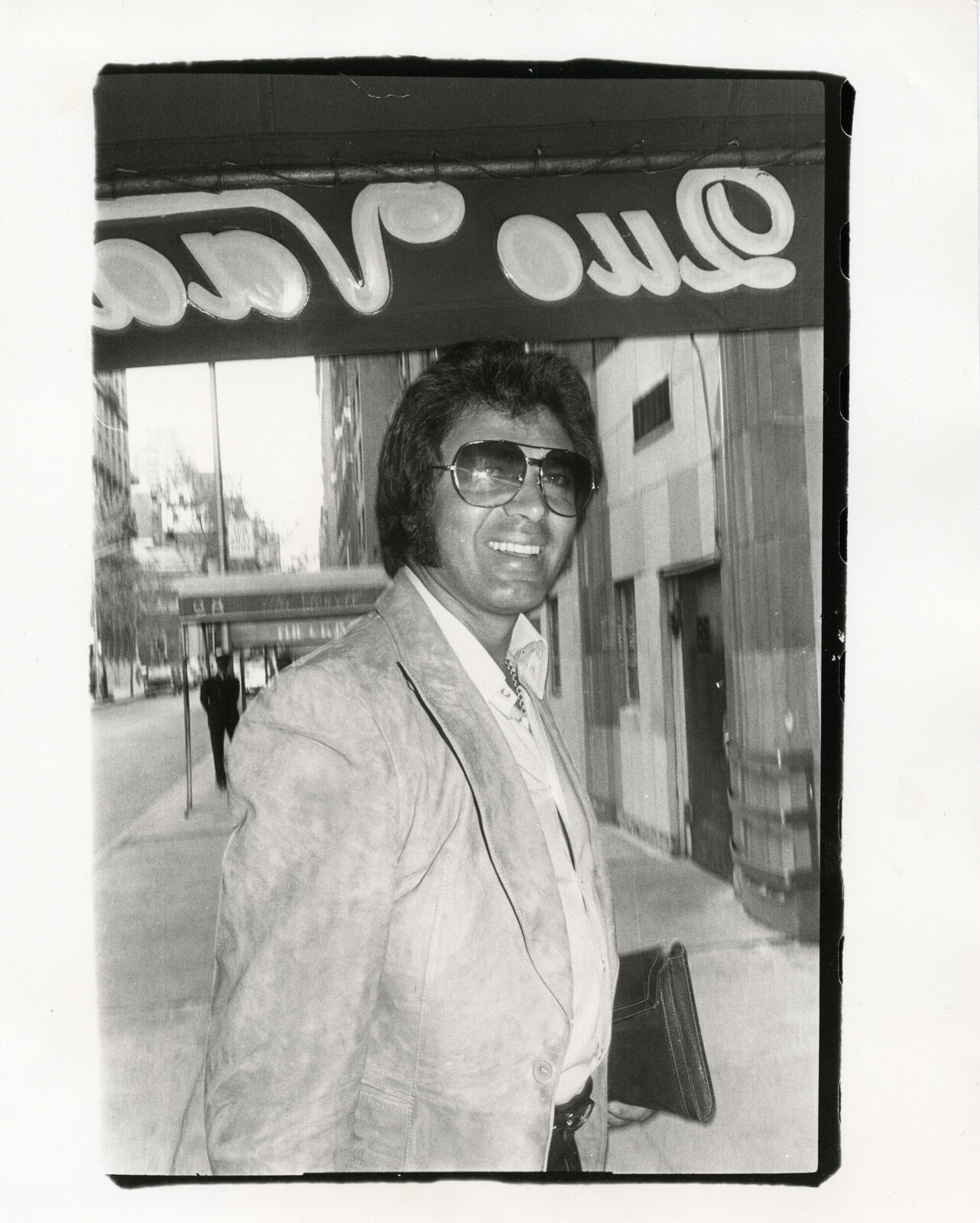 A black and white photo of a man in a suit and sunglasses.