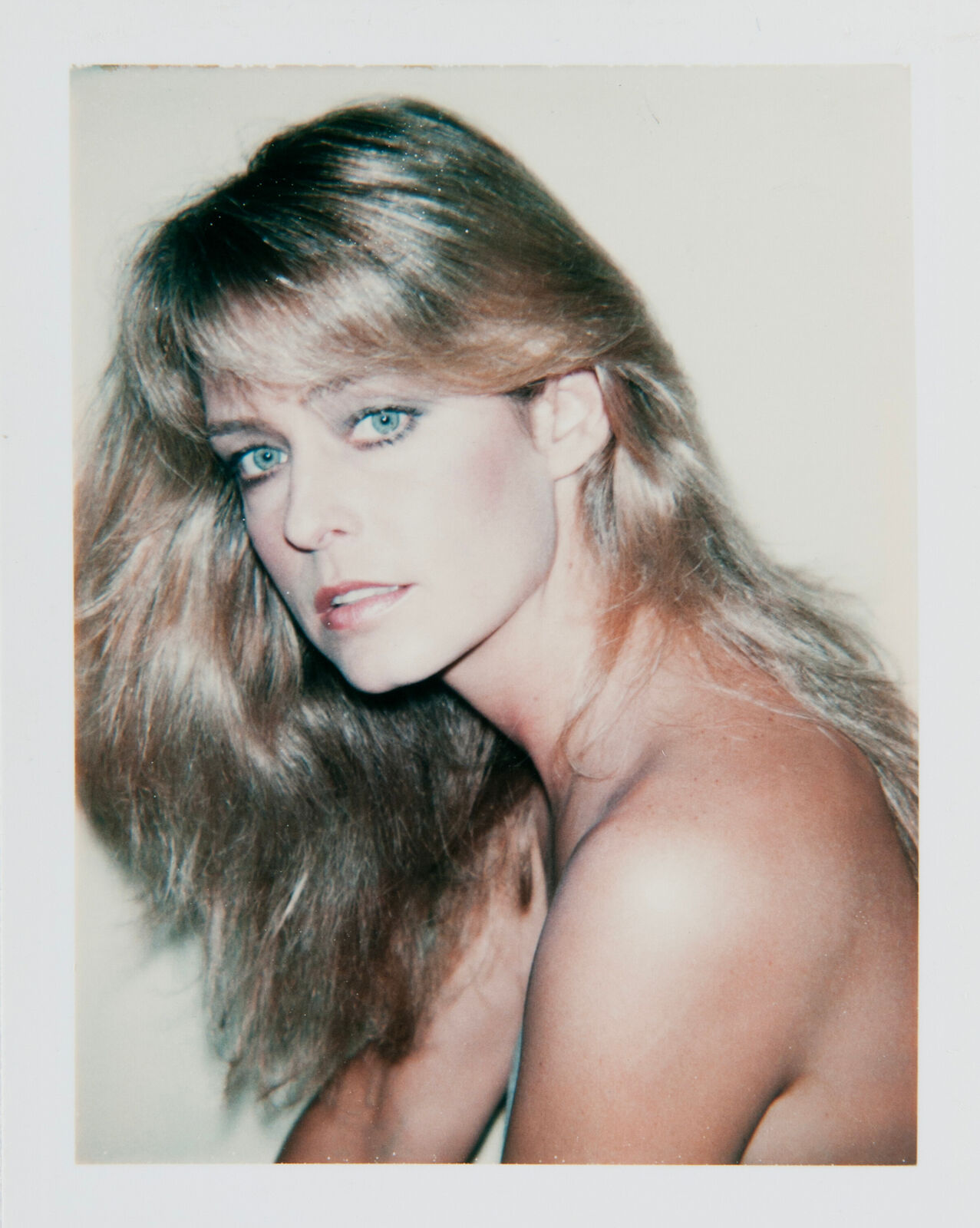 A woman with long blonde hair and blue eyes posing for a picture.