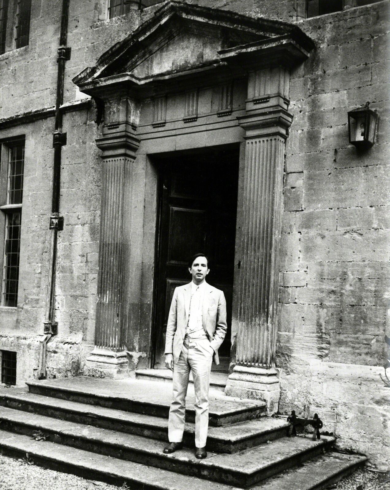 A man in a suit standing on the steps of a building.