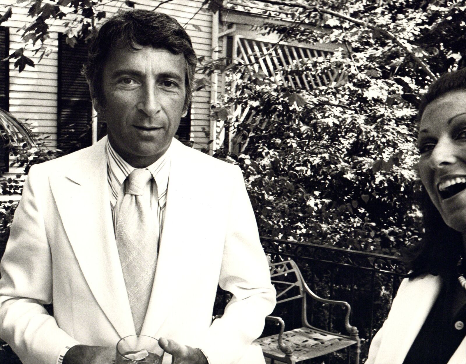 A man and a woman standing next to each other on a patio.