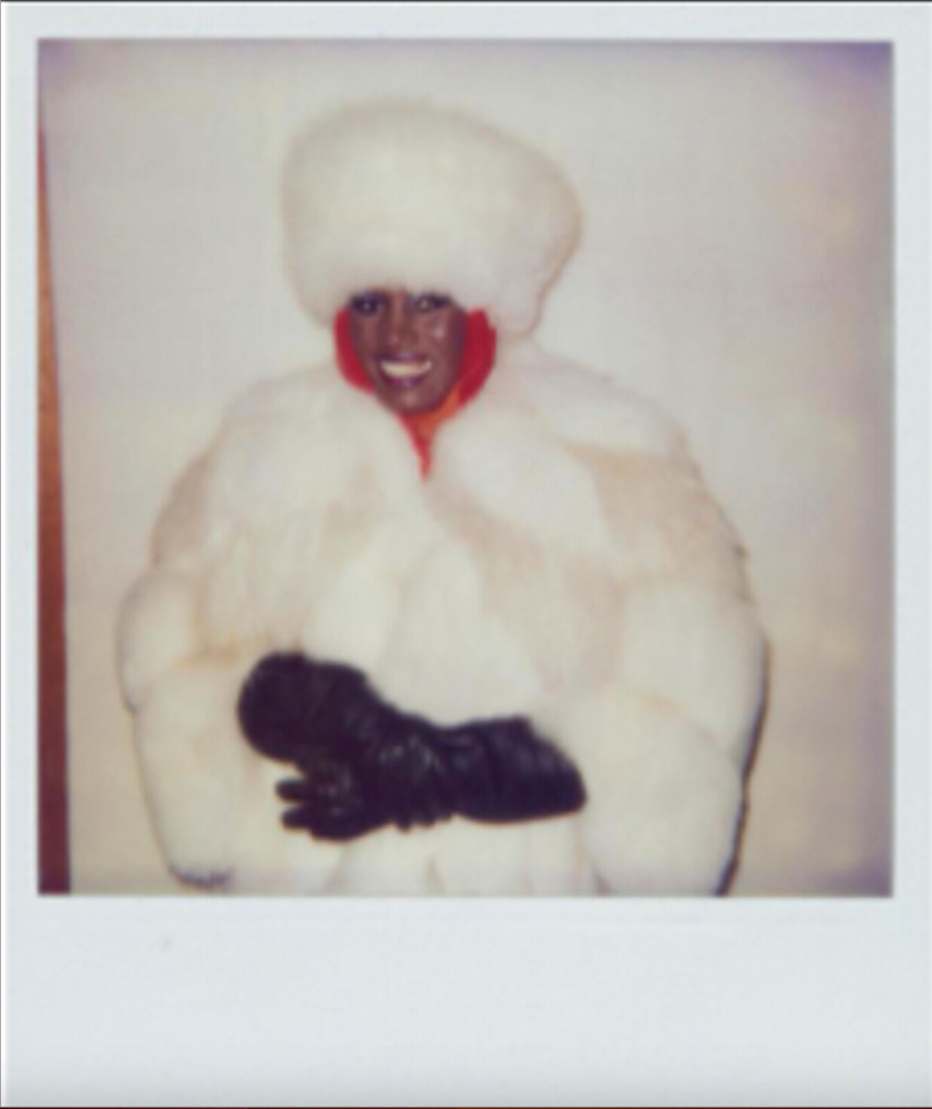 A woman in a white fur coat and black gloves.