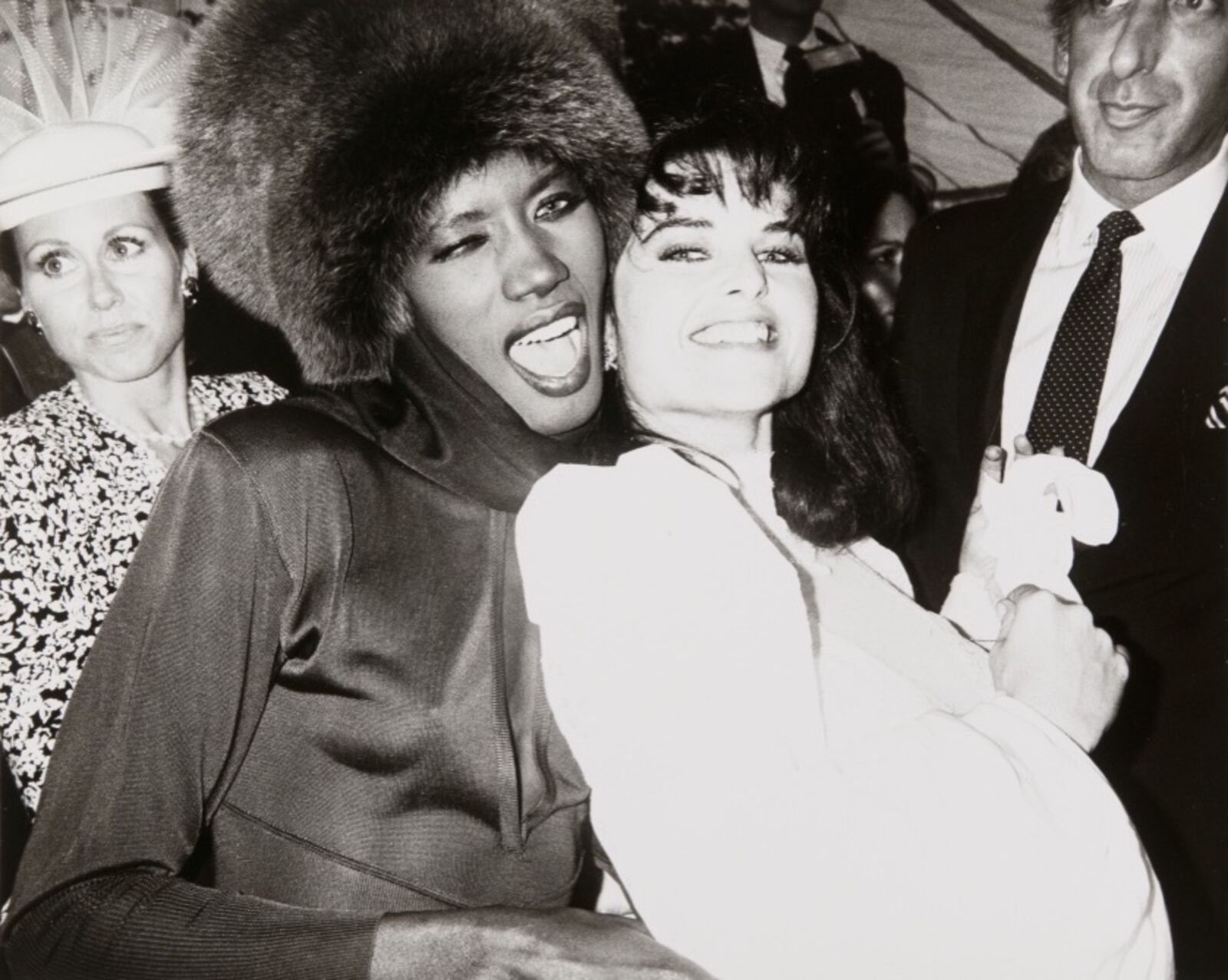 A black and white photo of a woman in a fur hat and a man in a suit.