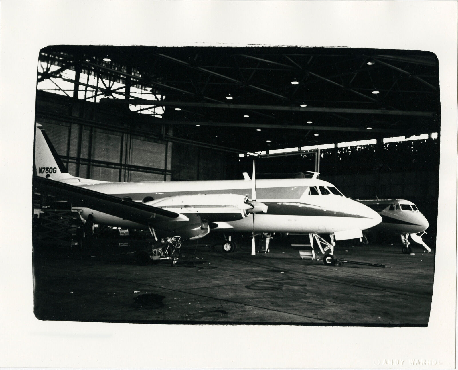 A black and white photo of an airplane in a hangar.