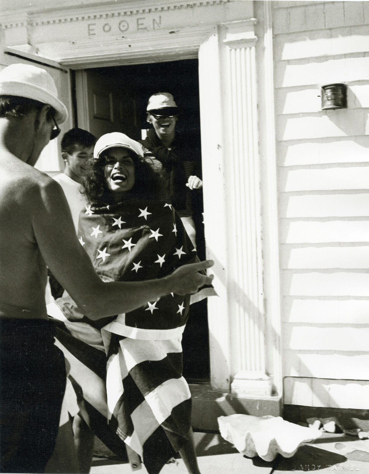A black and white photo of a woman holding an American flag.