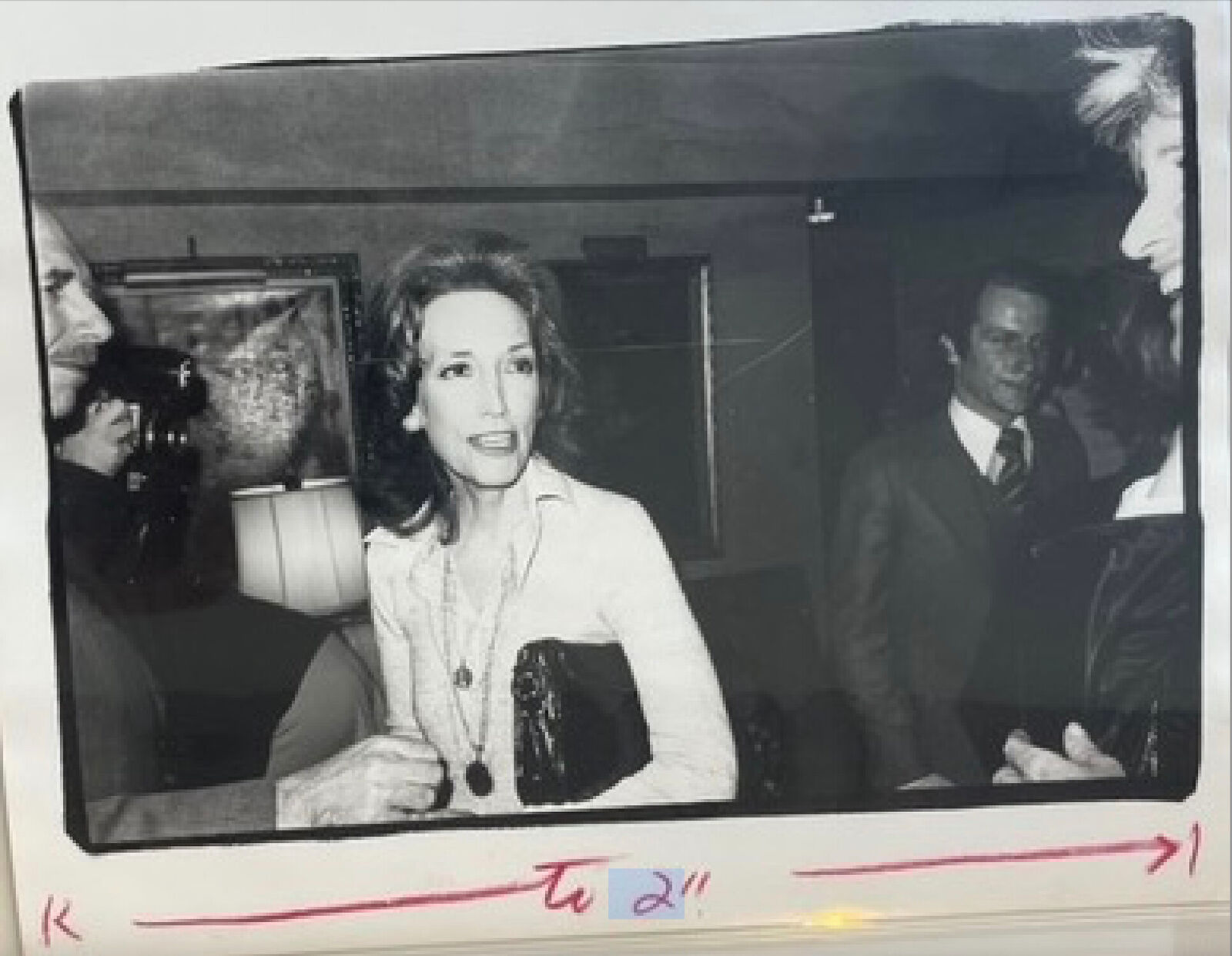A black and white photo of a woman sitting at a table.