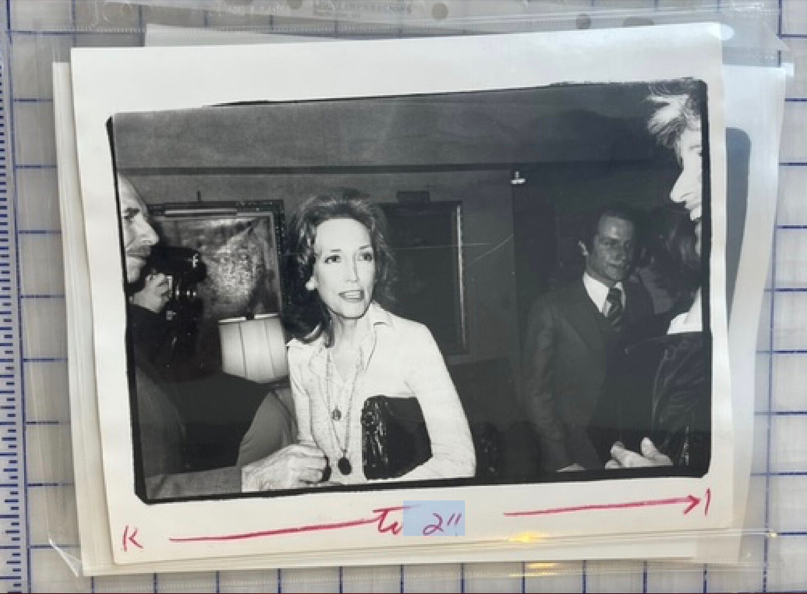 A black and white photo of a woman sitting at a table.