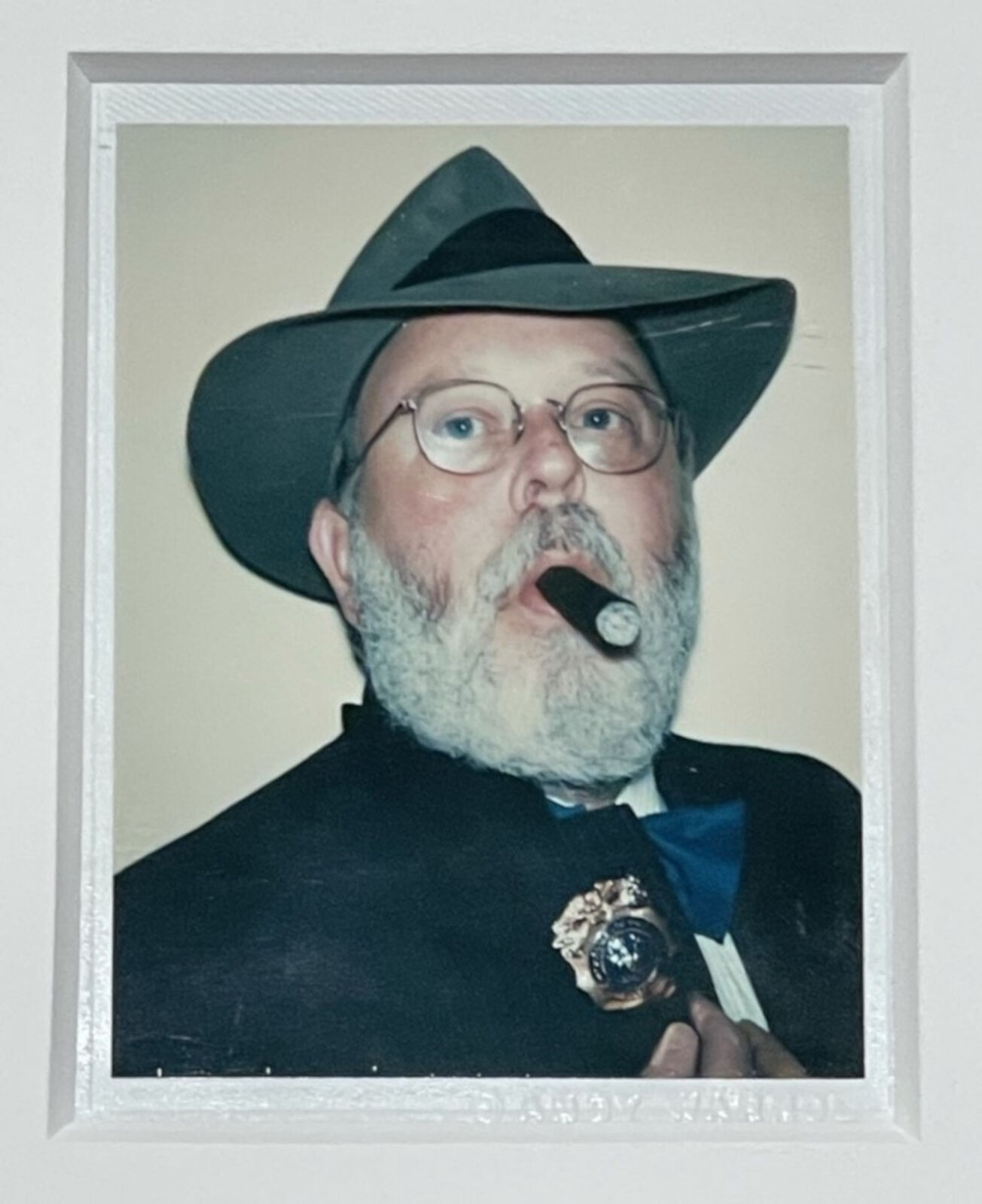 A man with a hat and a cigar in his mouth.