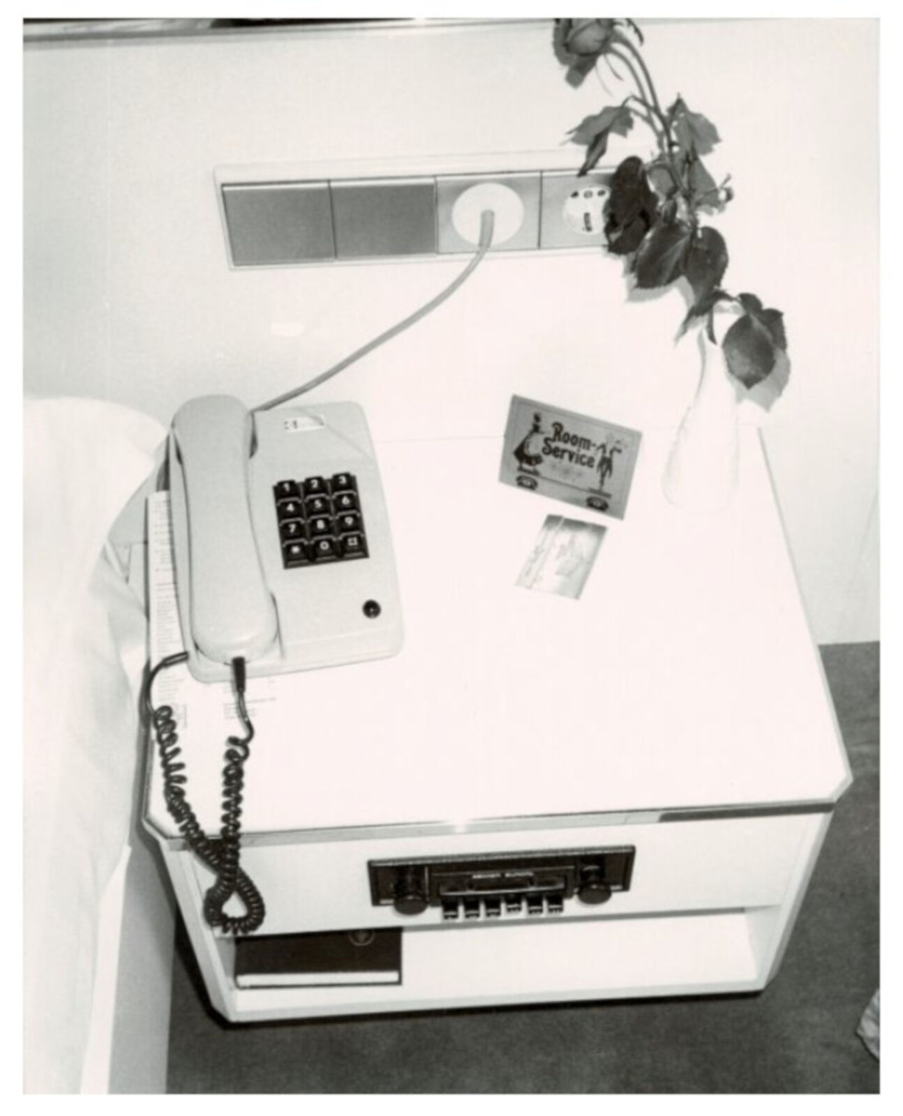 A black and white photo of a desk with a telephone on it.
