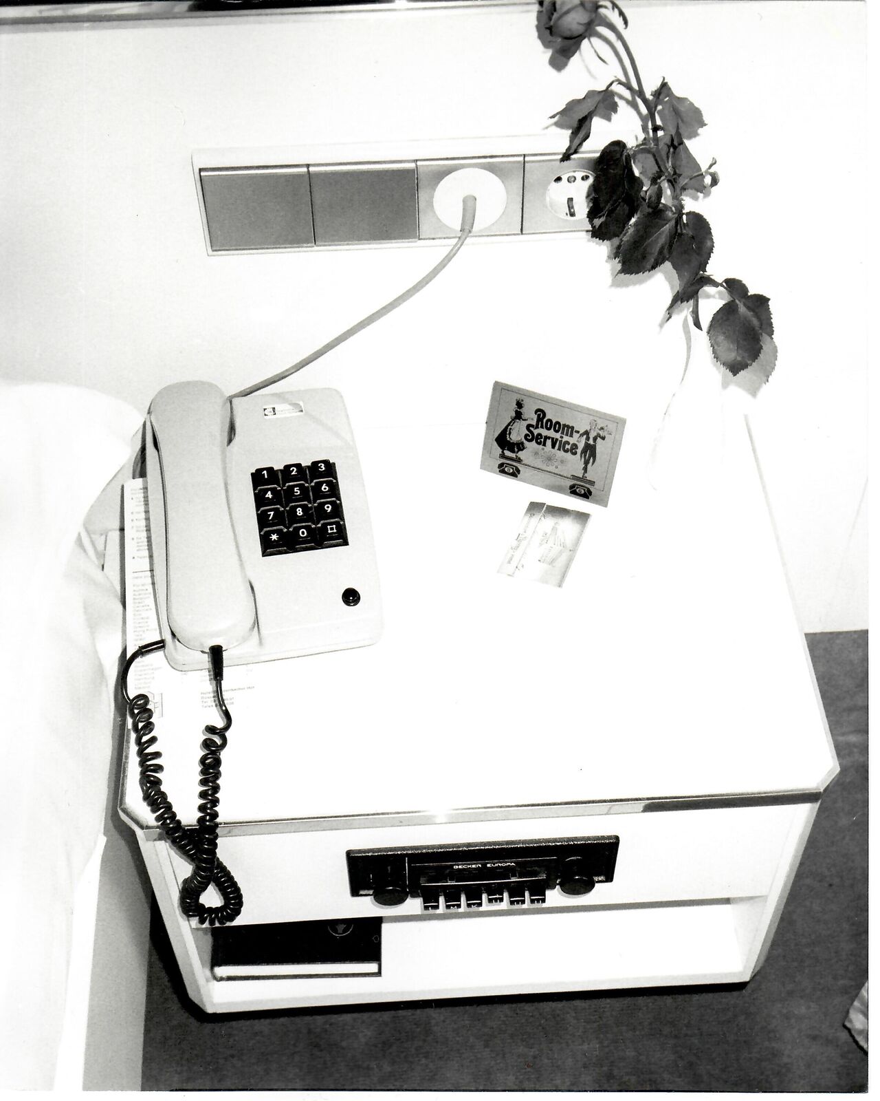 A black and white photo of a desk with a telephone on it.