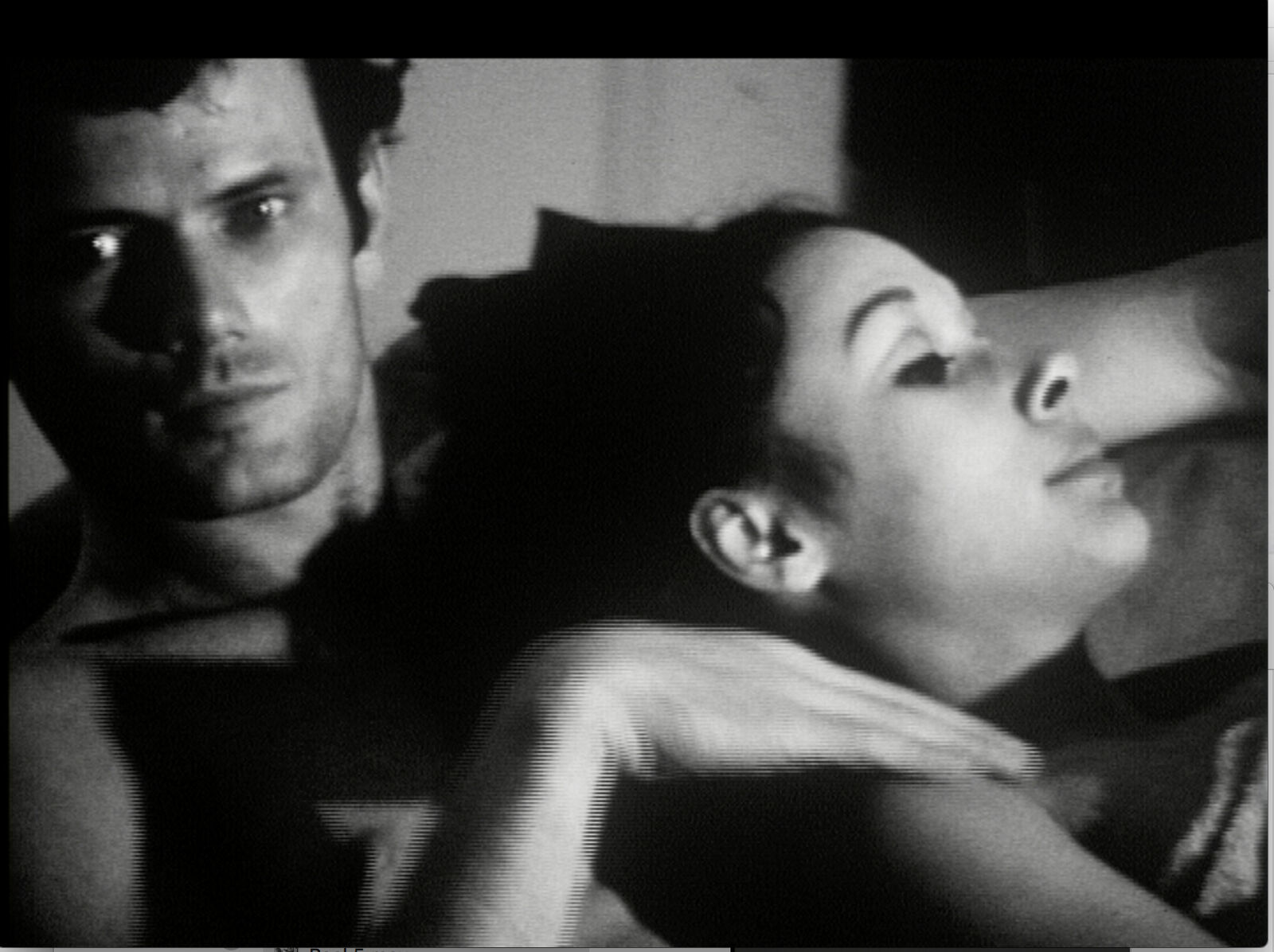 A man and a woman laying on top of a bed.