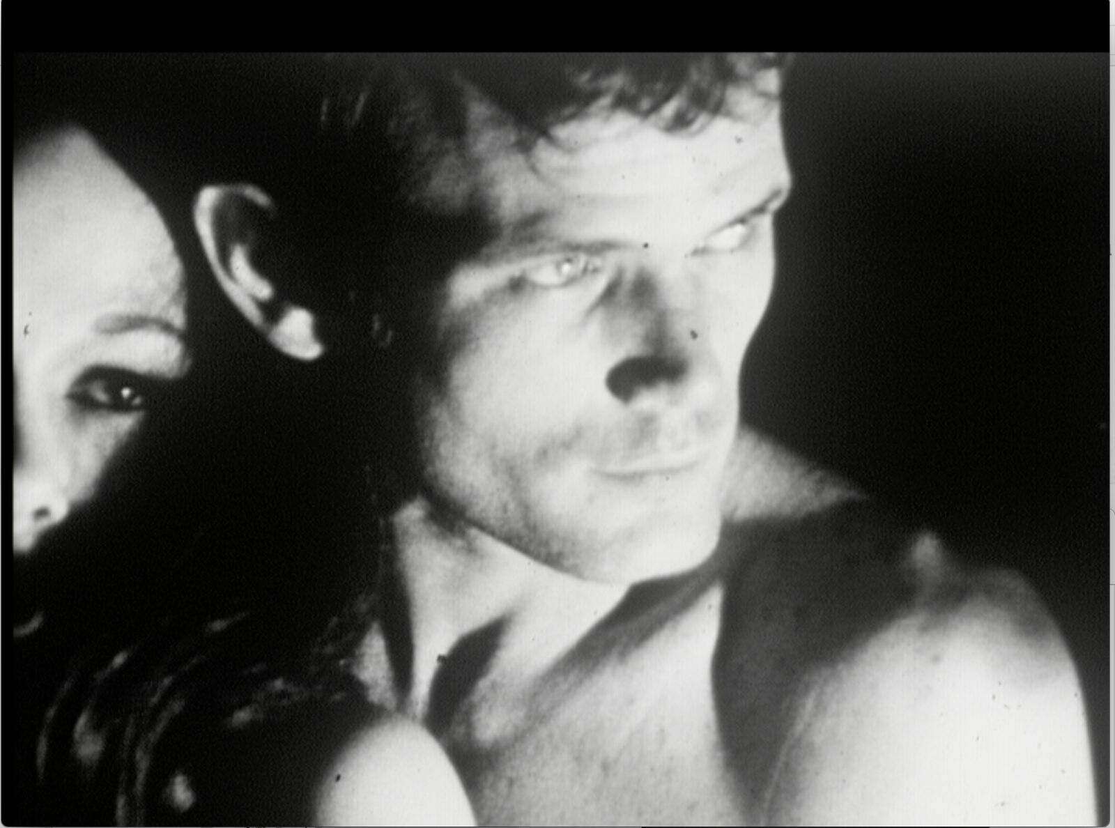 A man and a woman laying on top of a bed.