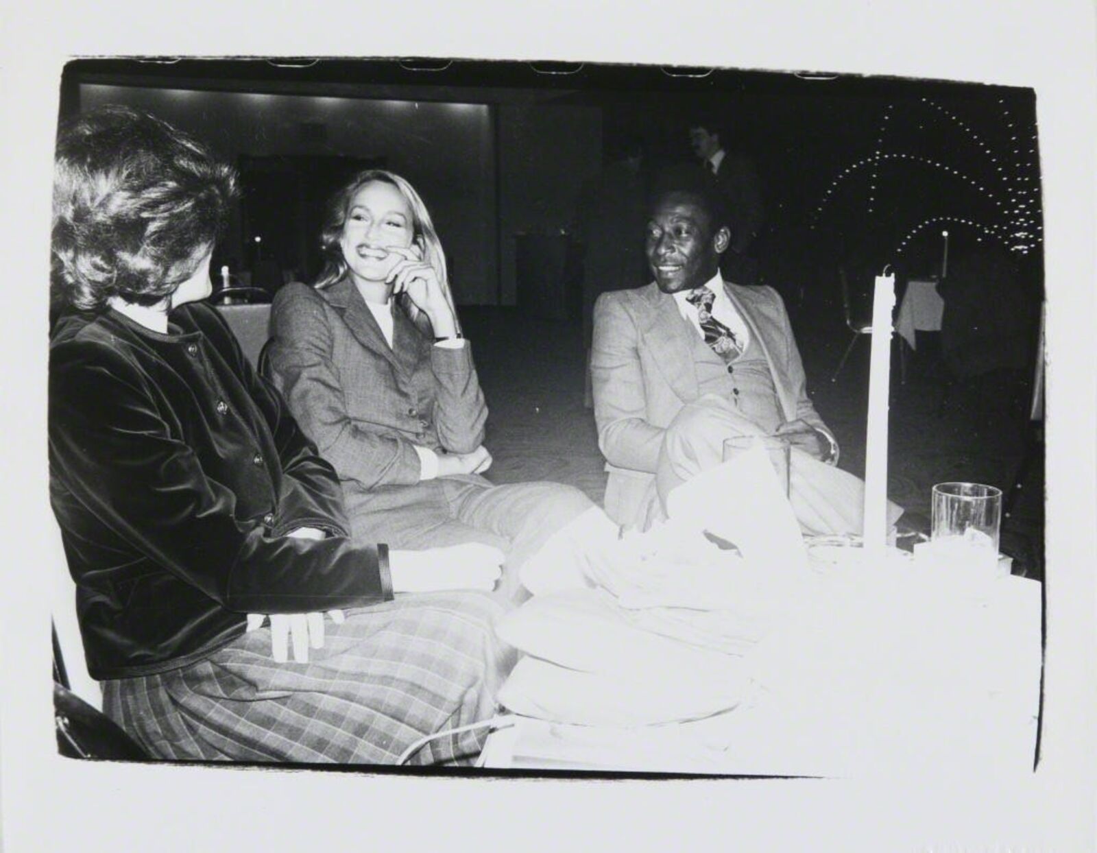 A black and white photo of two women and a man sitting at a table.