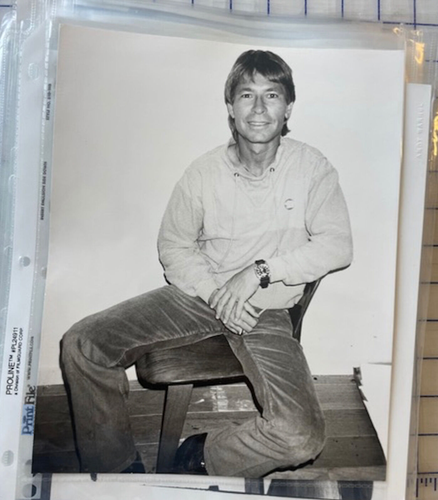 A black and white photo of a man sitting on a chair.