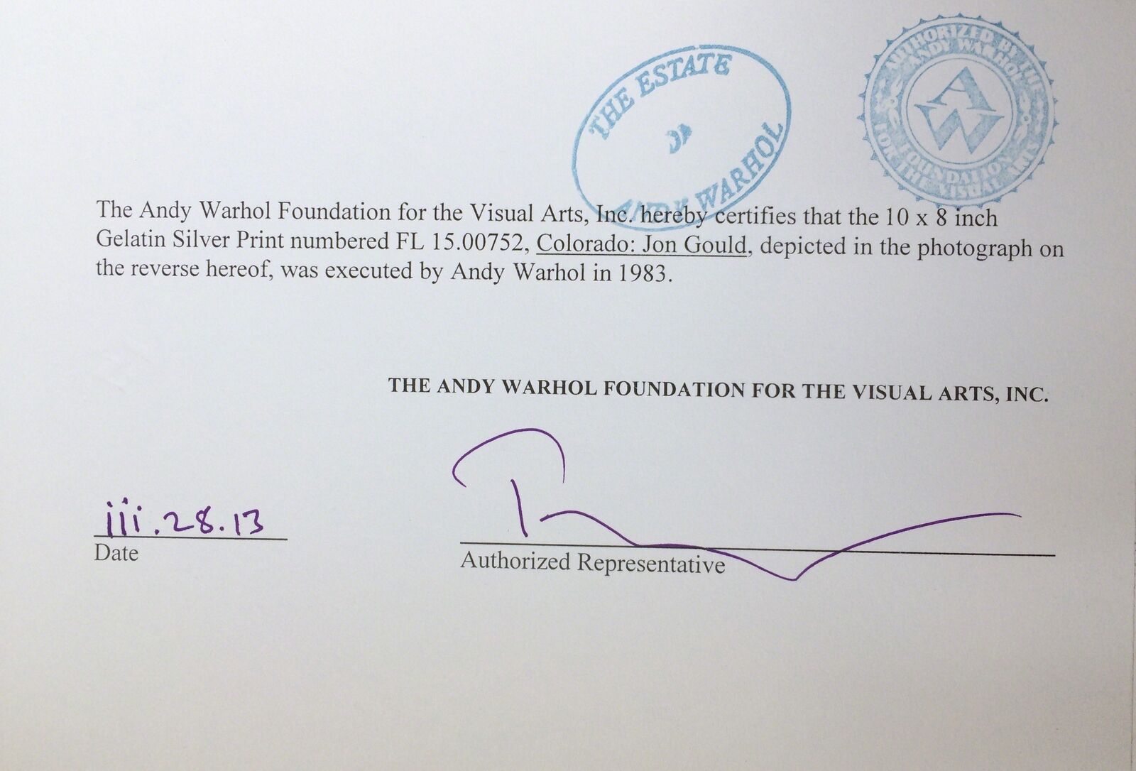 A man standing in the snow next to a snow sculpture.