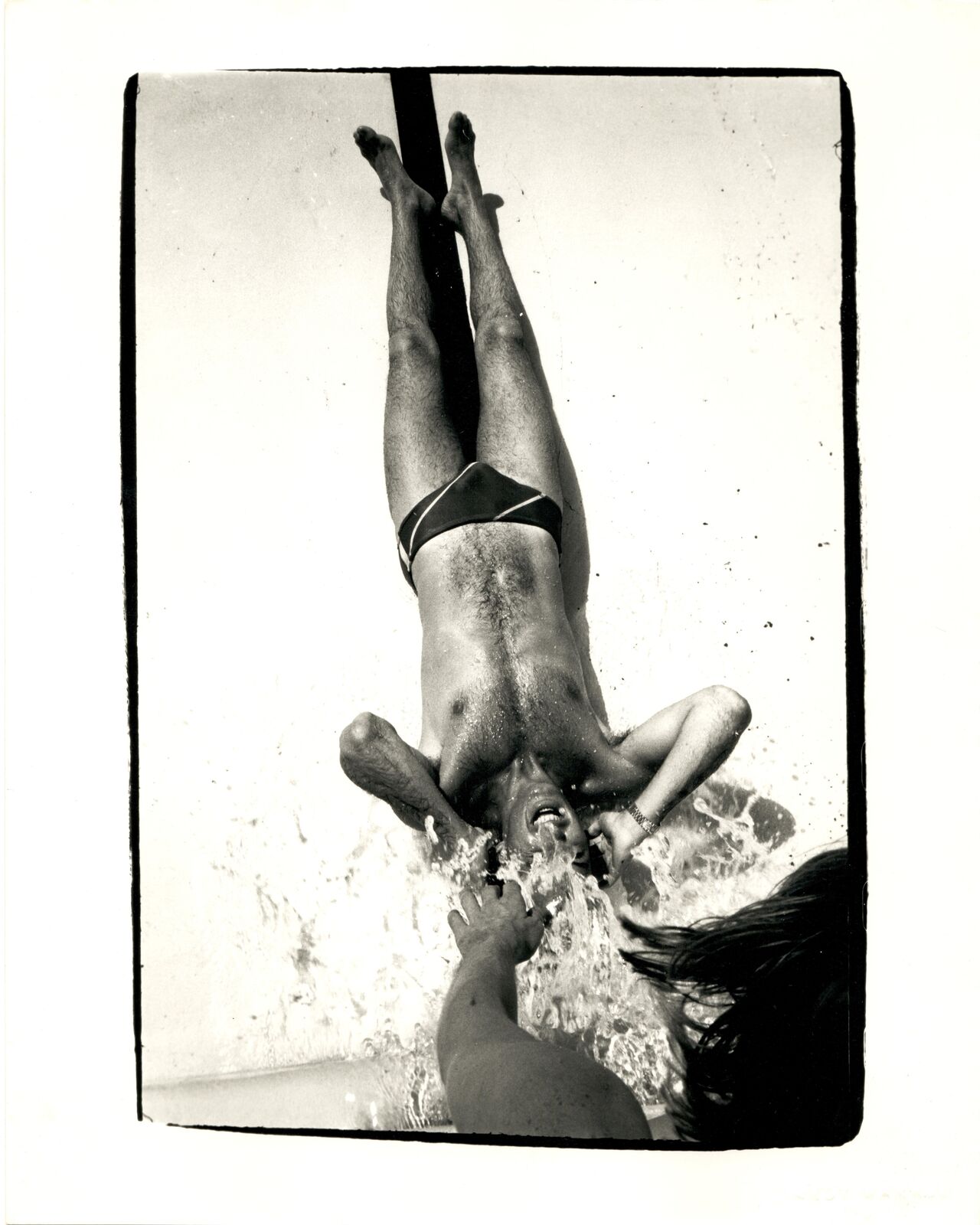 A black and white photo of a man falling into the water.
