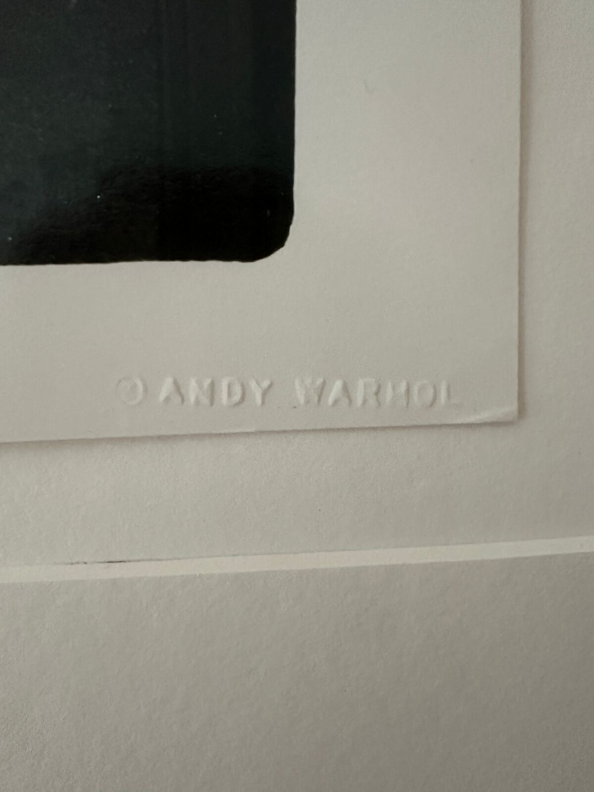 A shirtless man standing in front of a door with his arms outstretched.