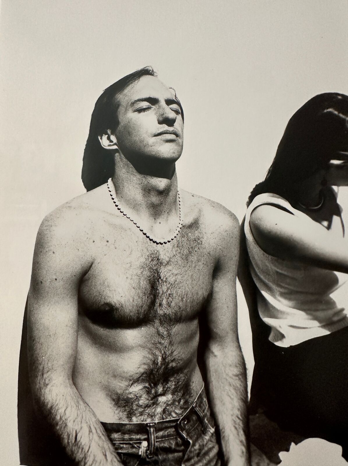 A shirtless man standing next to a woman.