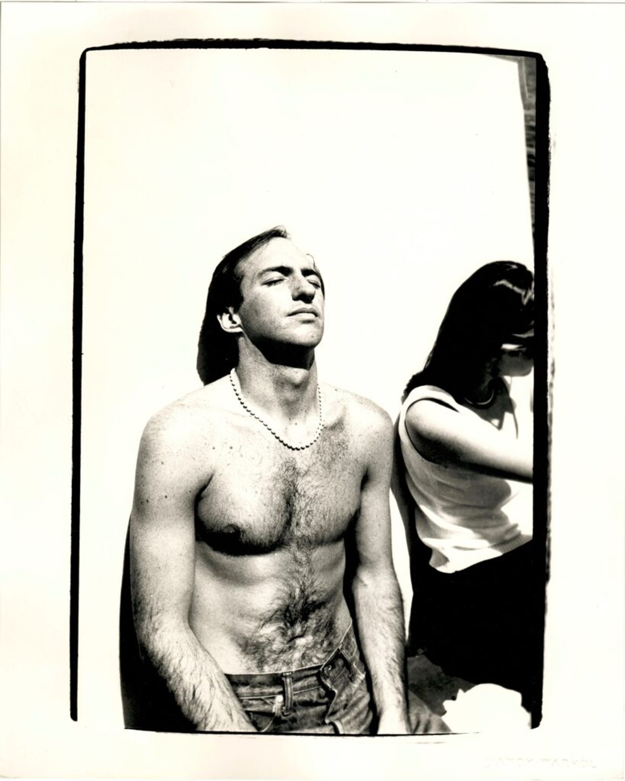 A shirtless man standing next to a woman.