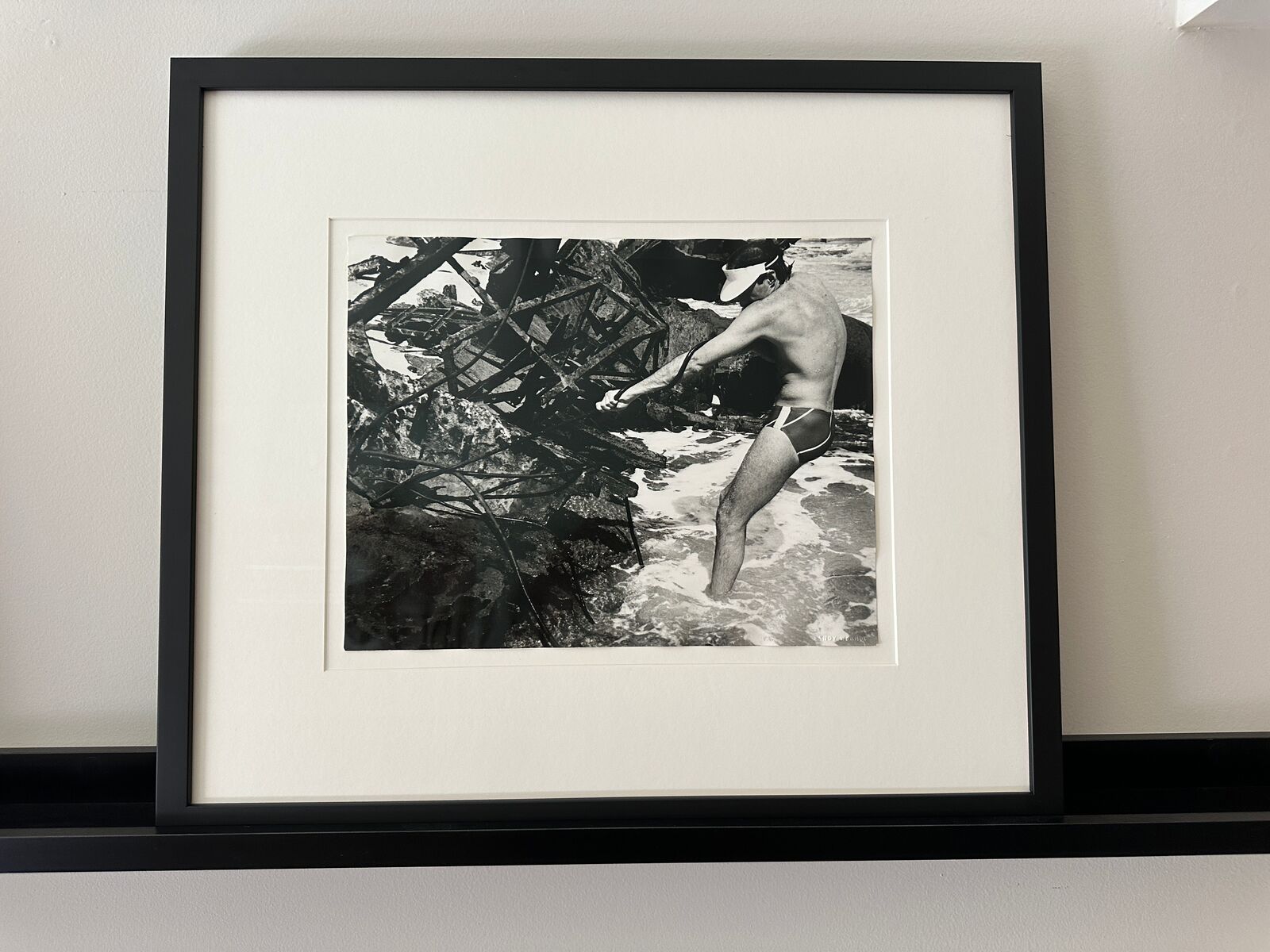 A man in a bathing suit standing in the water.