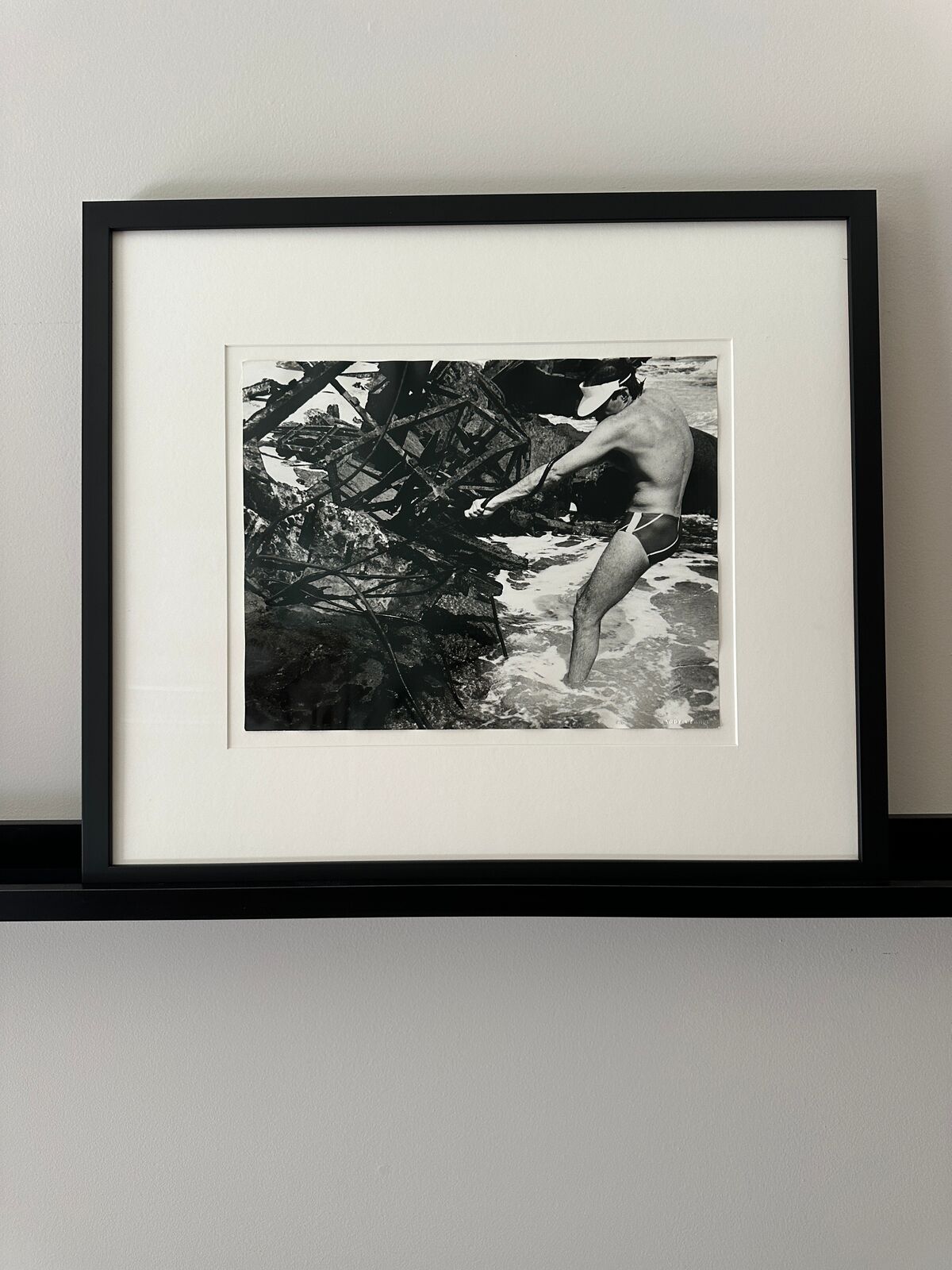 A man in a bathing suit standing in the water.