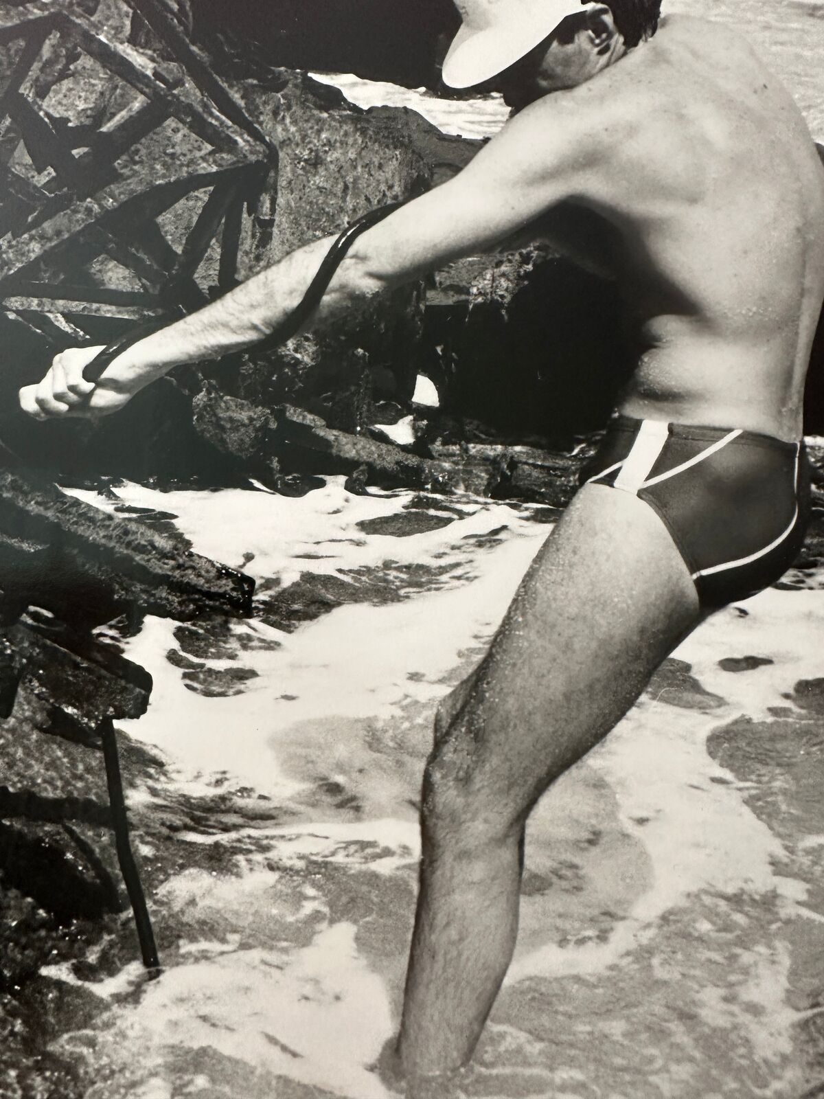 A man in a bathing suit standing in the water.
