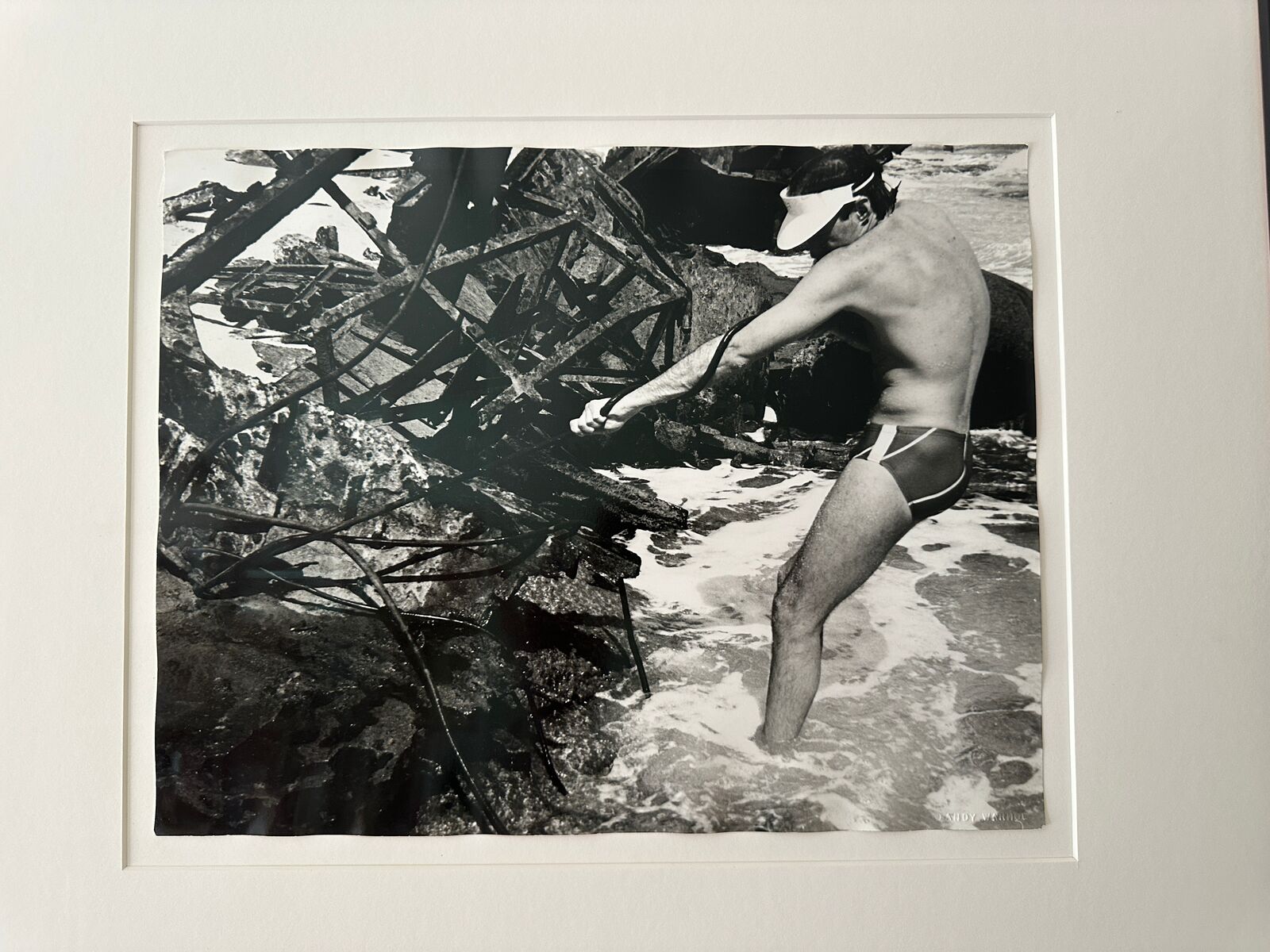 A man in a bathing suit standing in the water.
