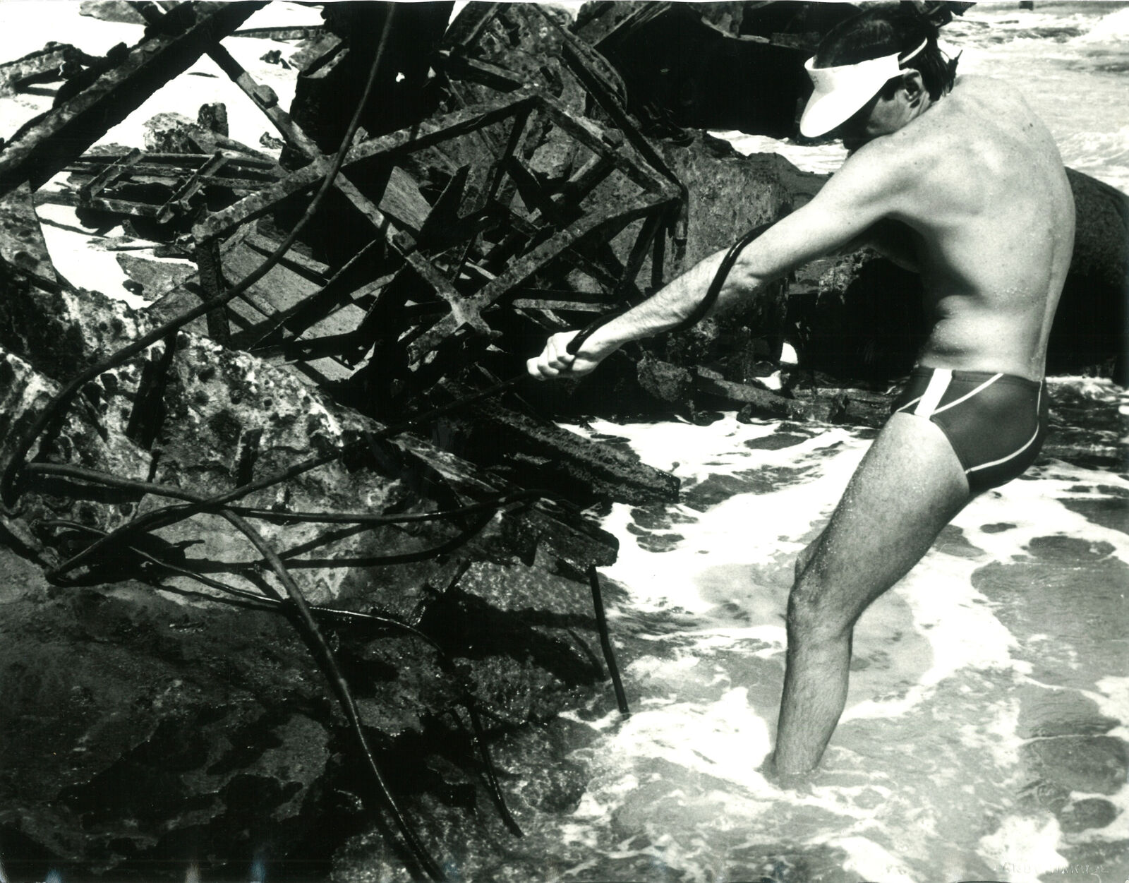 A man in a bathing suit standing in the water.