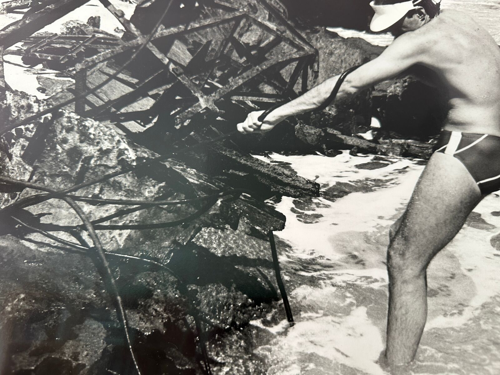 A man in a bathing suit standing in the water.