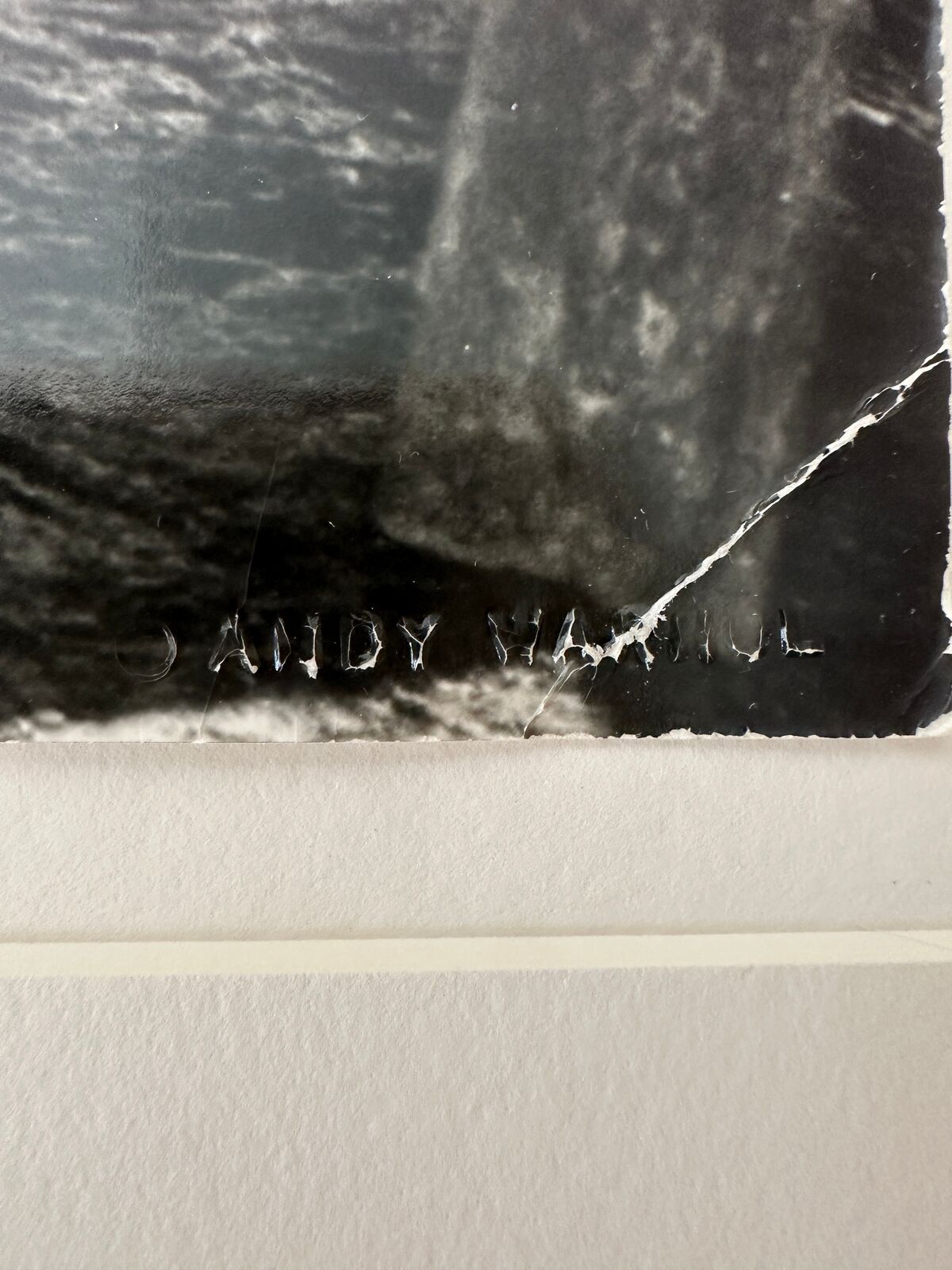 A man in a bathing suit and hat holding onto a rope.