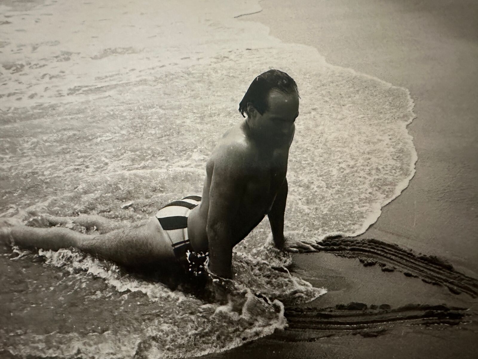 A man in a bathing suit is playing in the water.