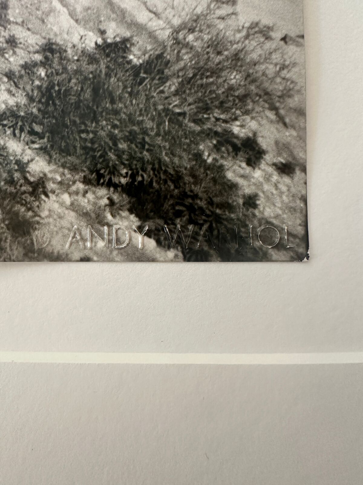 A black and white photo of a man walking on a cliff.