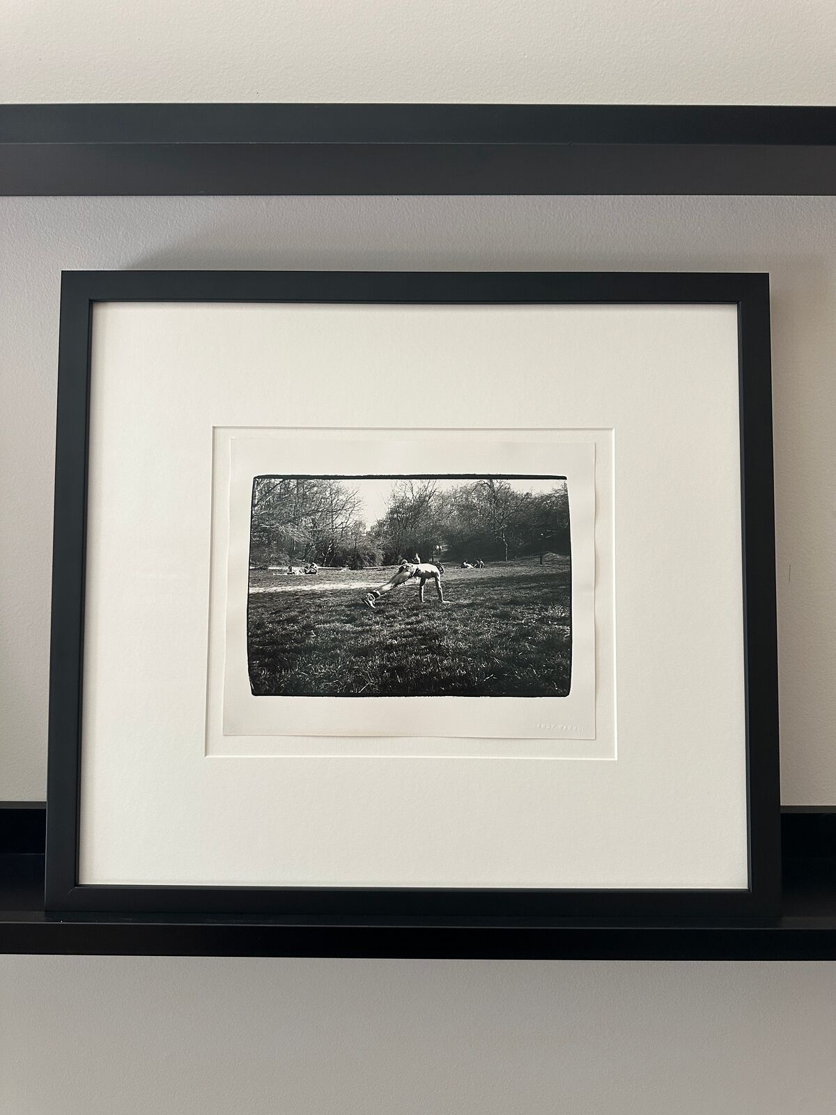 A black and white photo of a man doing a handstand in a park.