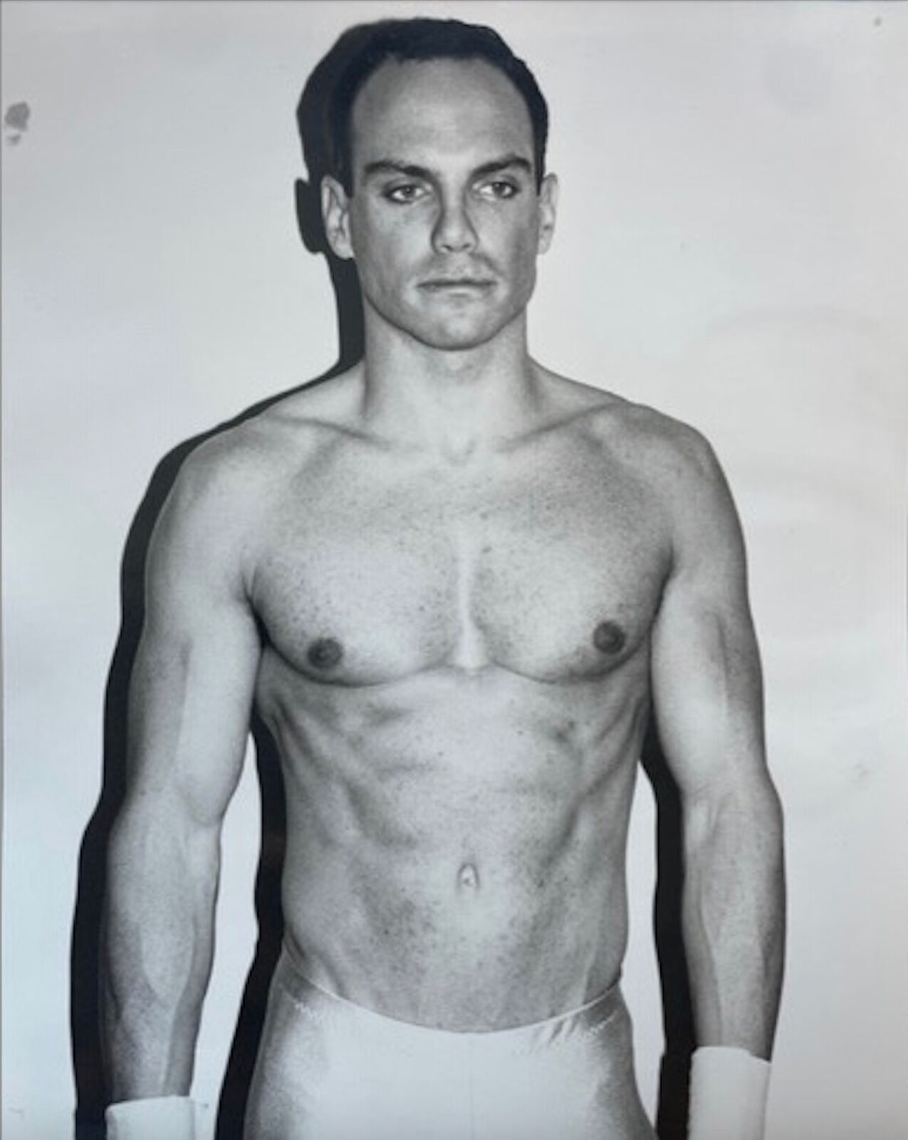 A shirtless man in a white underwear posing for a picture.
