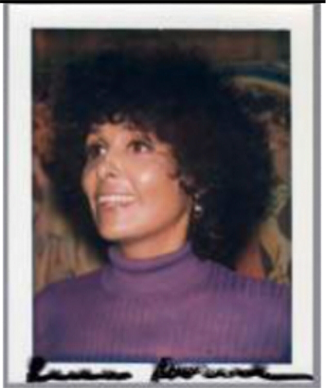 A polaroid photo of a woman with an afro smiling.