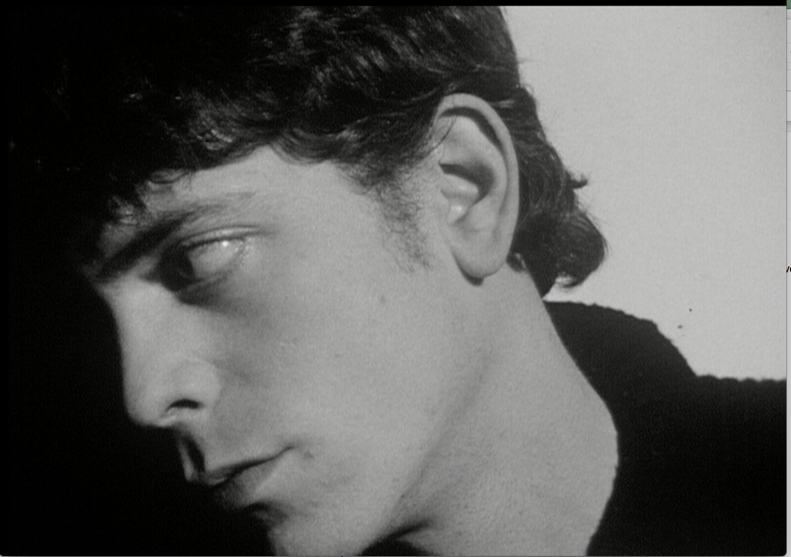 A black and white photo of a young man with dark hair.