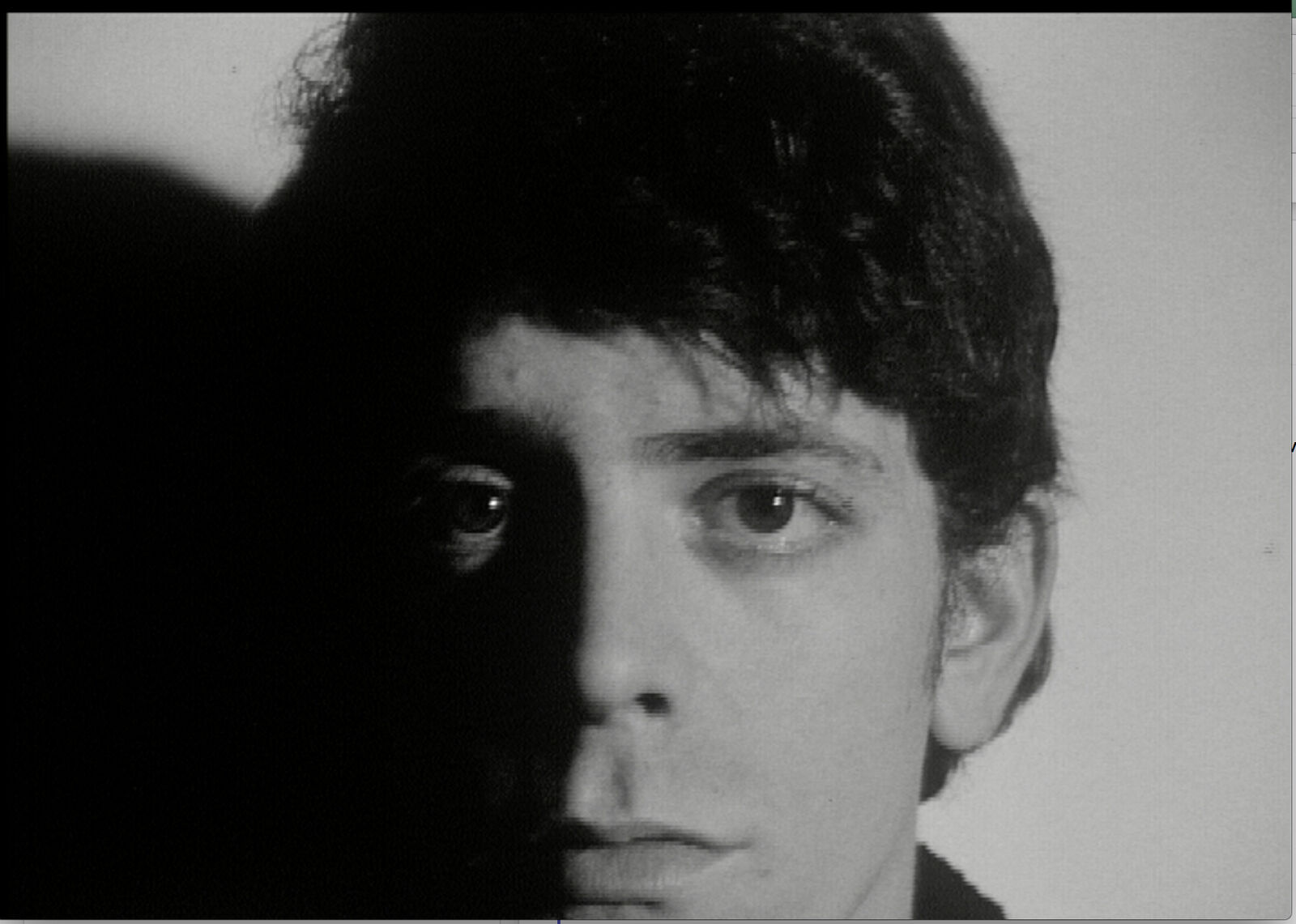 A black and white photo of a young man with dark hair.