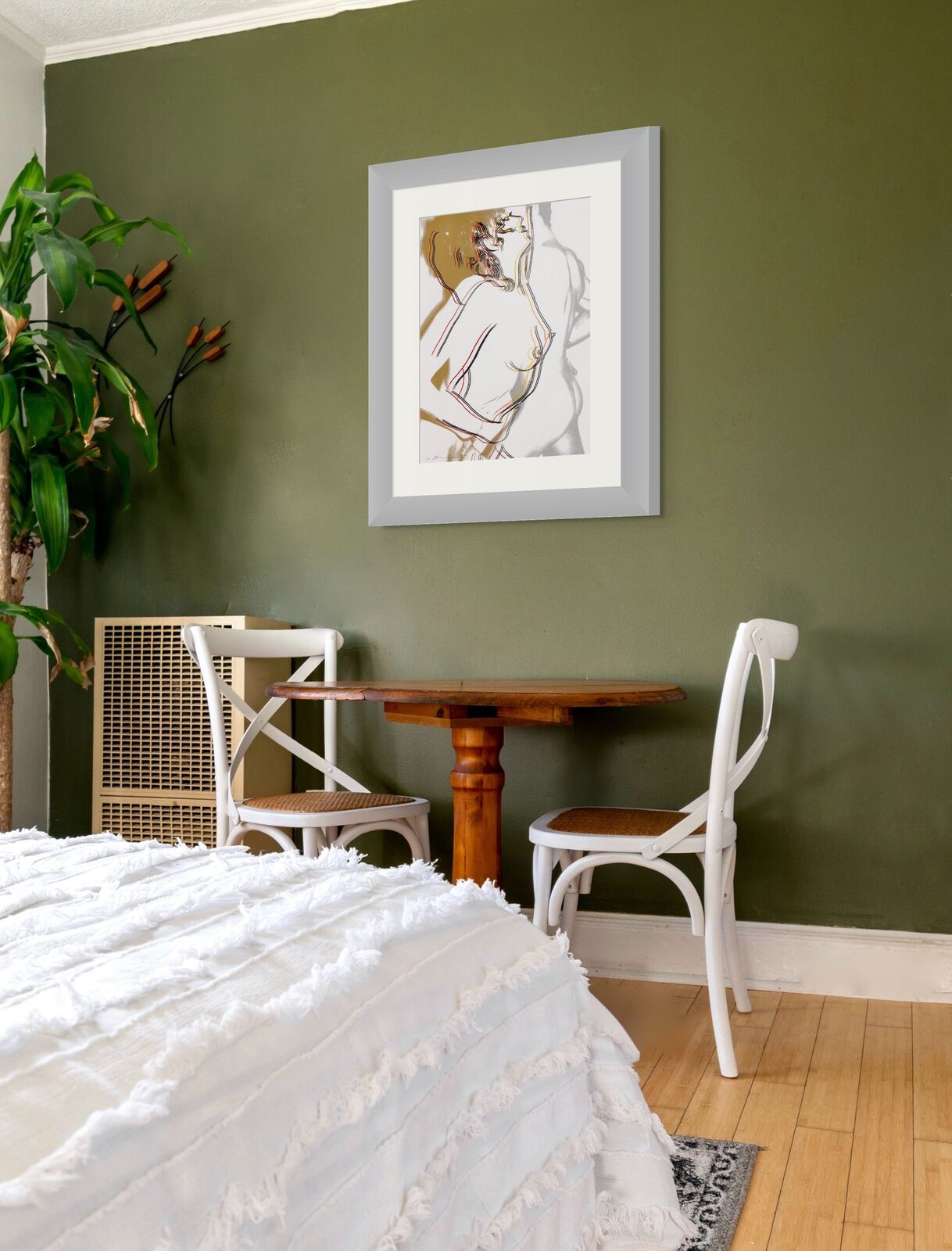 A bedroom with a bed and three framed pictures on the wall.
